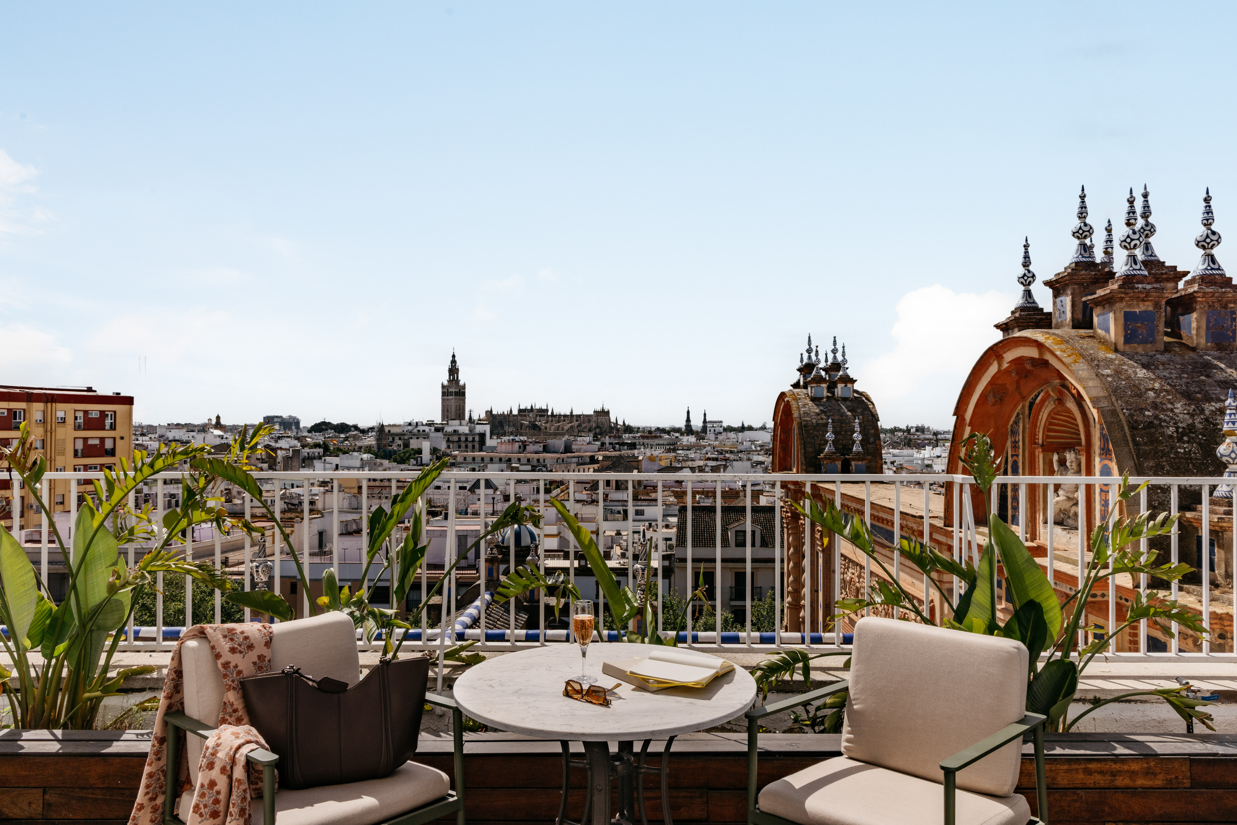 Seville rooftop terrace with Giralda tower view and outdoor lounge setup.