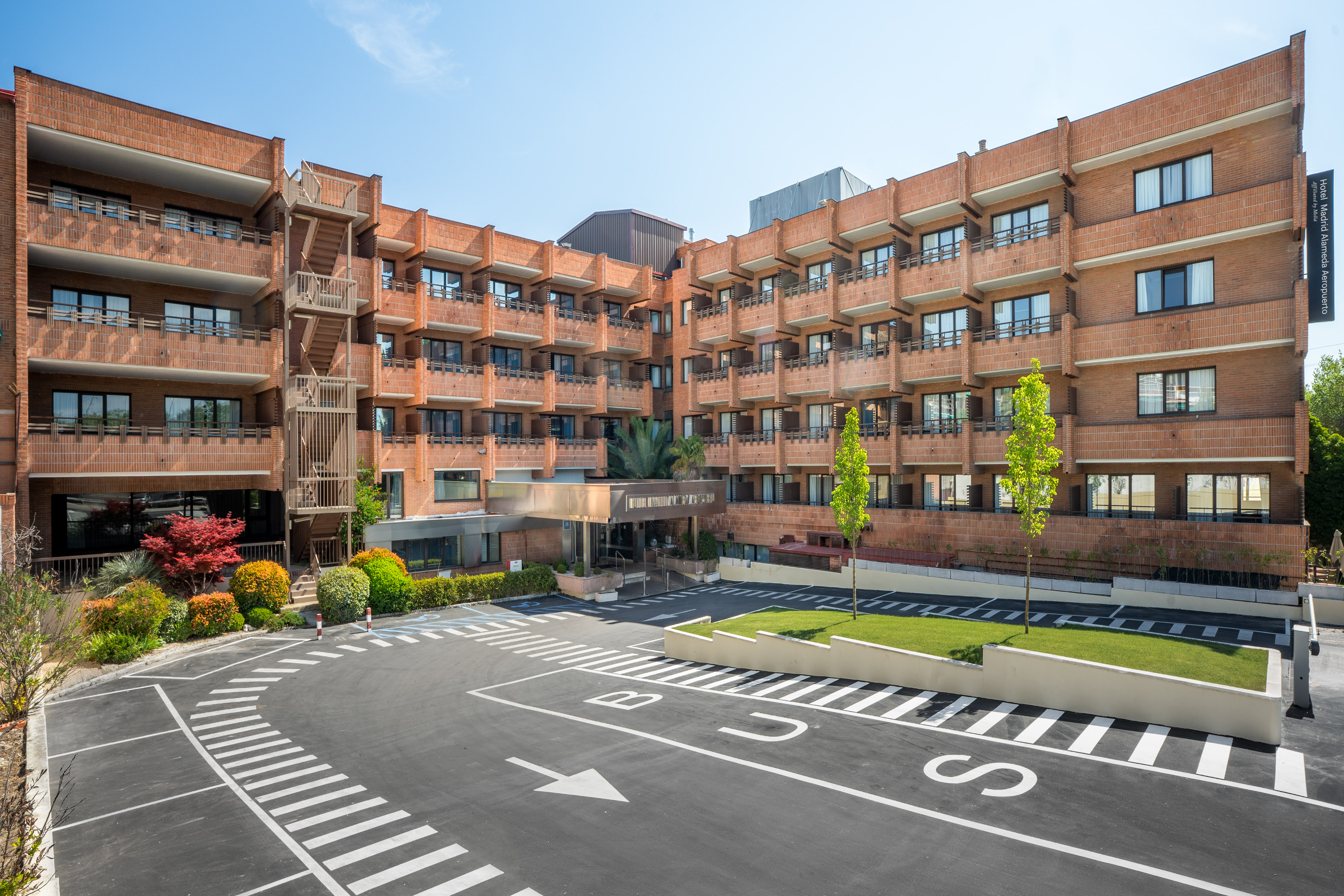 Hotel Madrid Alameda Aeropuerto exterior, brick building, parking lot.