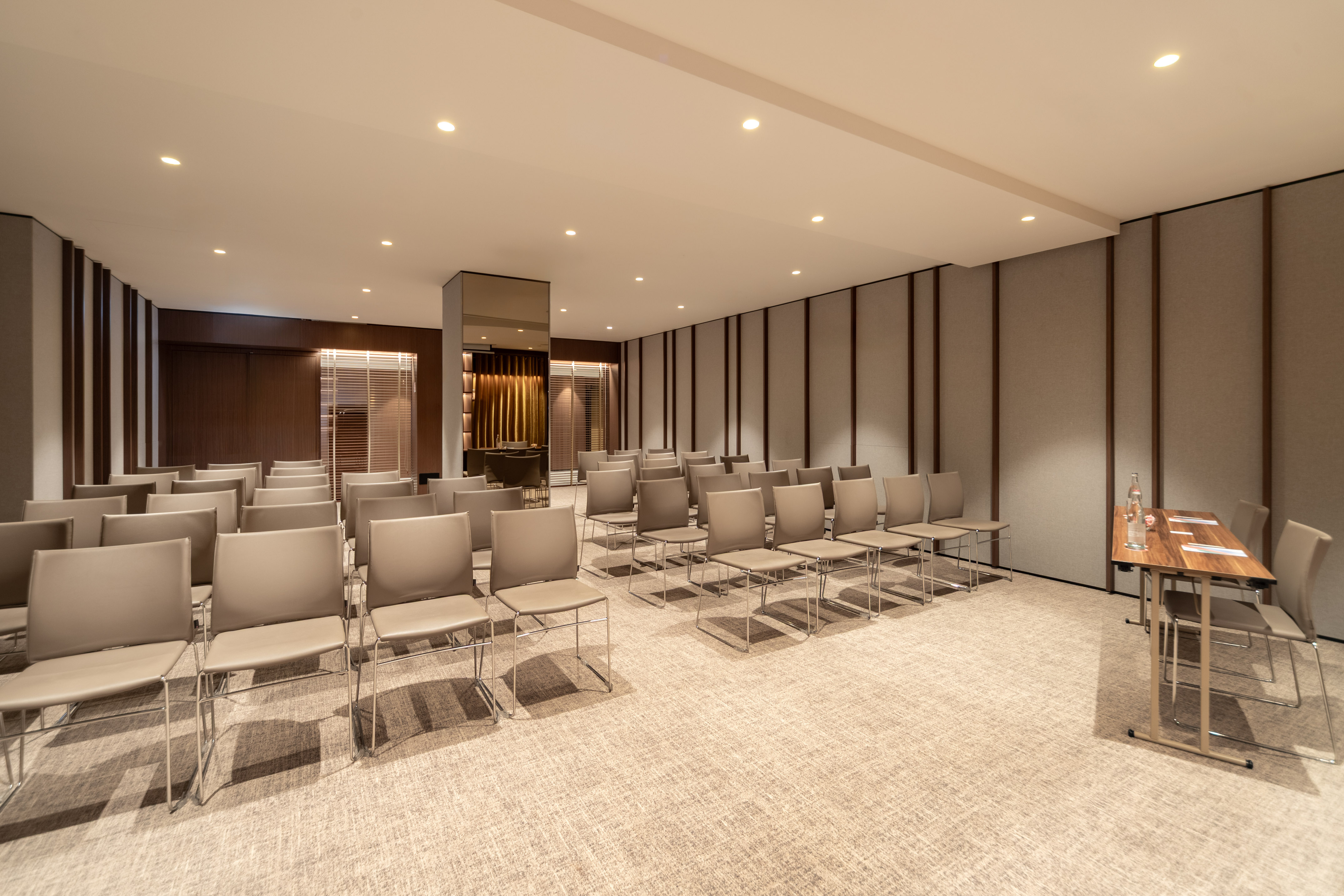Modern conference room with rows of beige chairs, ready for events.