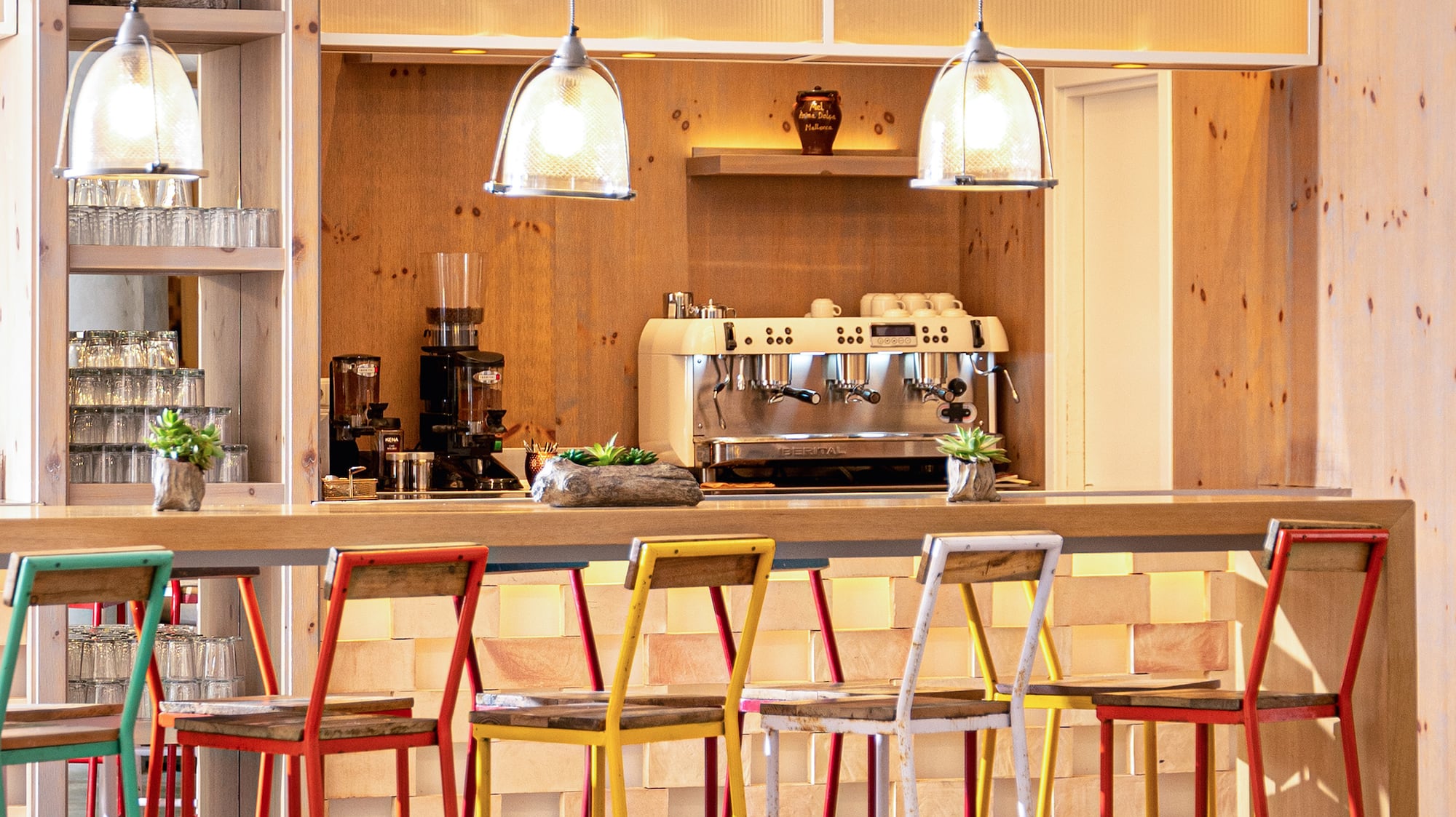 a bar with colorful stools and lights