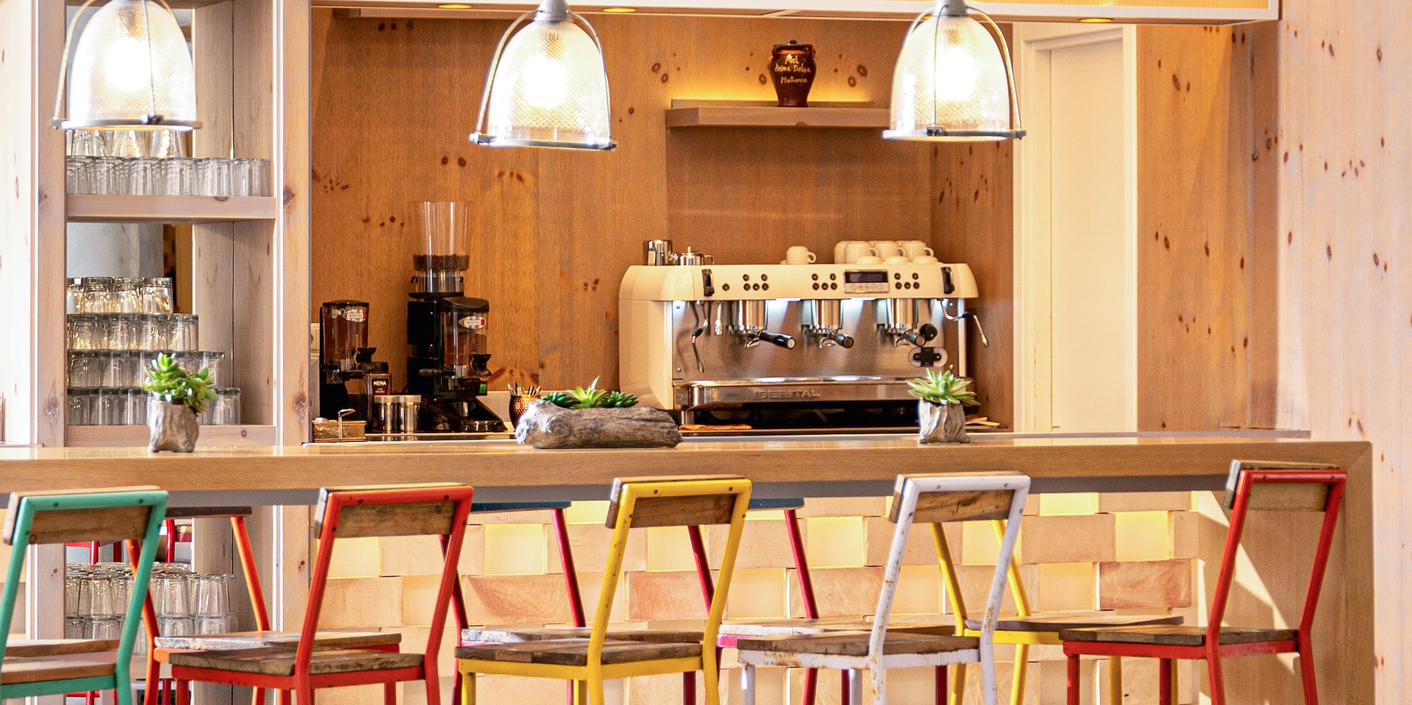 a bar with colorful stools and lights