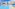 Sunny resort pool with blue sun loungers, palm trees, and white hotel building.