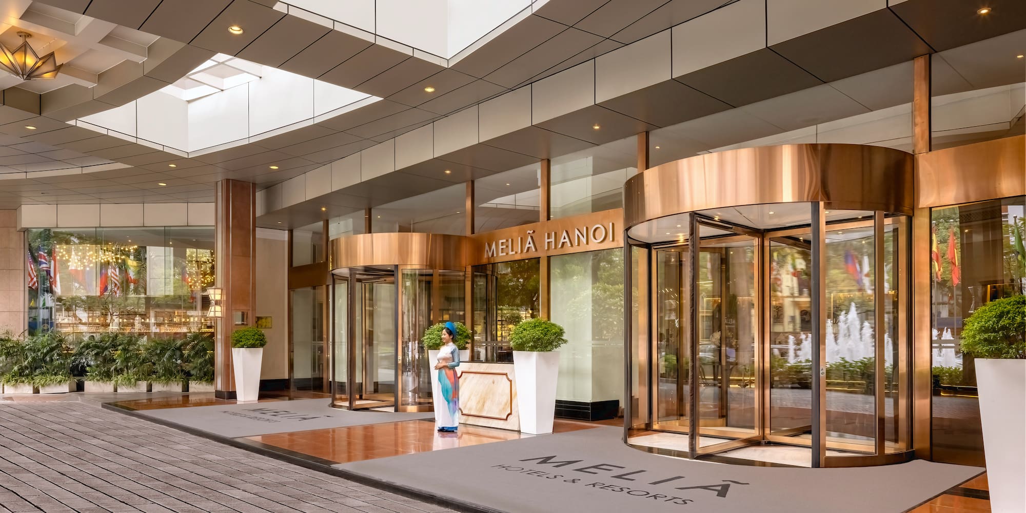 a building with glass doors and a woman standing in front of it