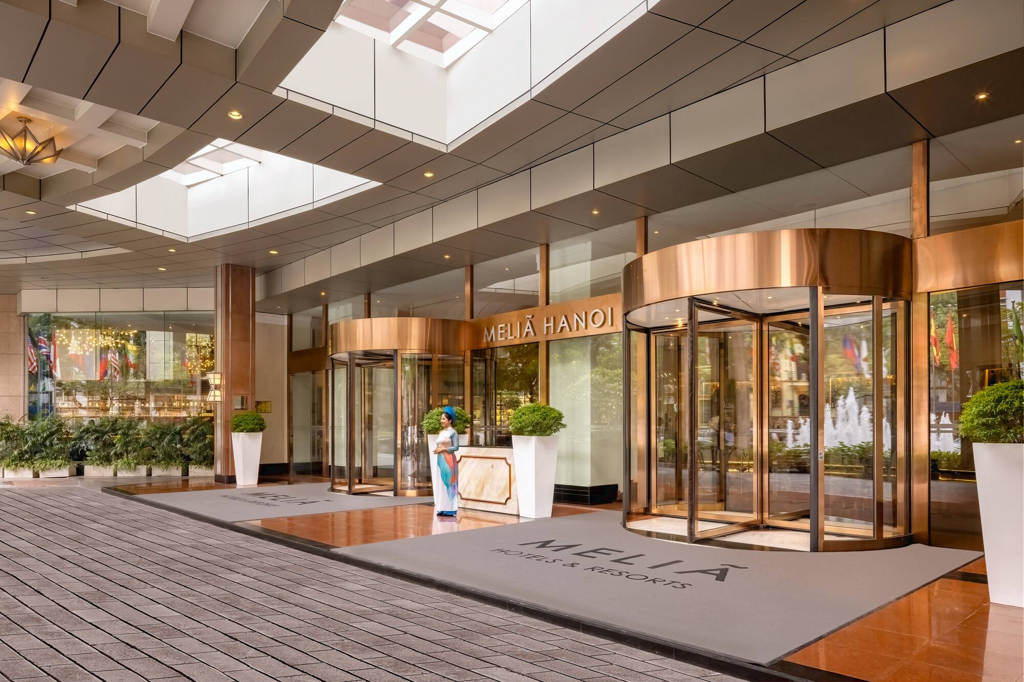 a building with glass doors and a woman standing in front of it