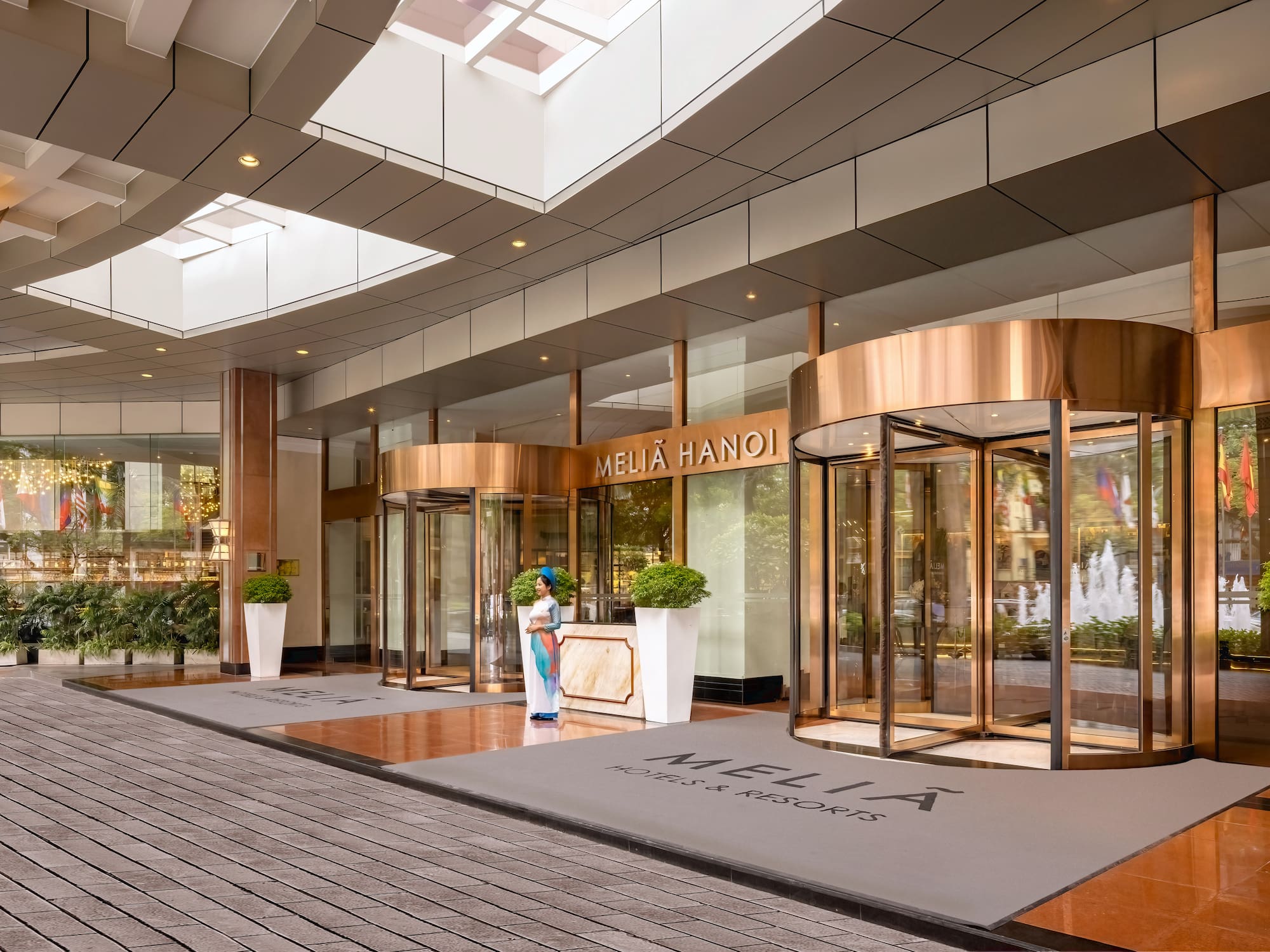 a building with glass doors and a woman standing in front of it