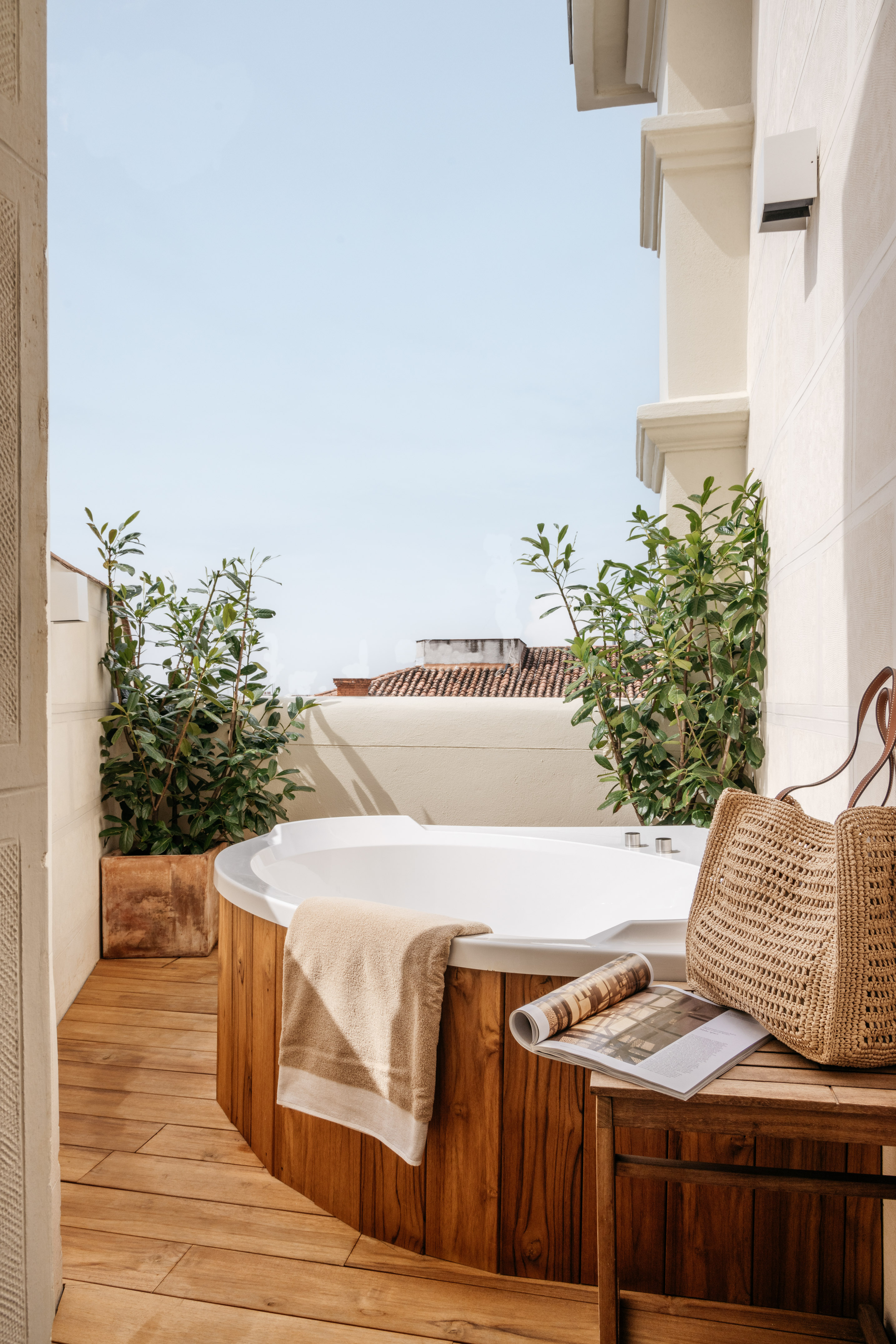 a hot tub with a magazine and a bag on a deck