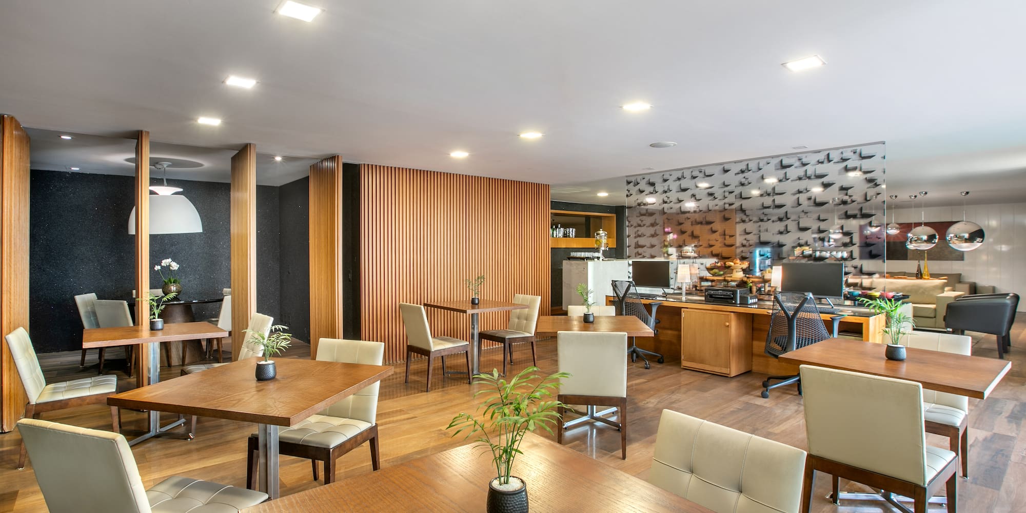 Modern lounge interior with wooden tables, cream chairs, and slatted wood decor.