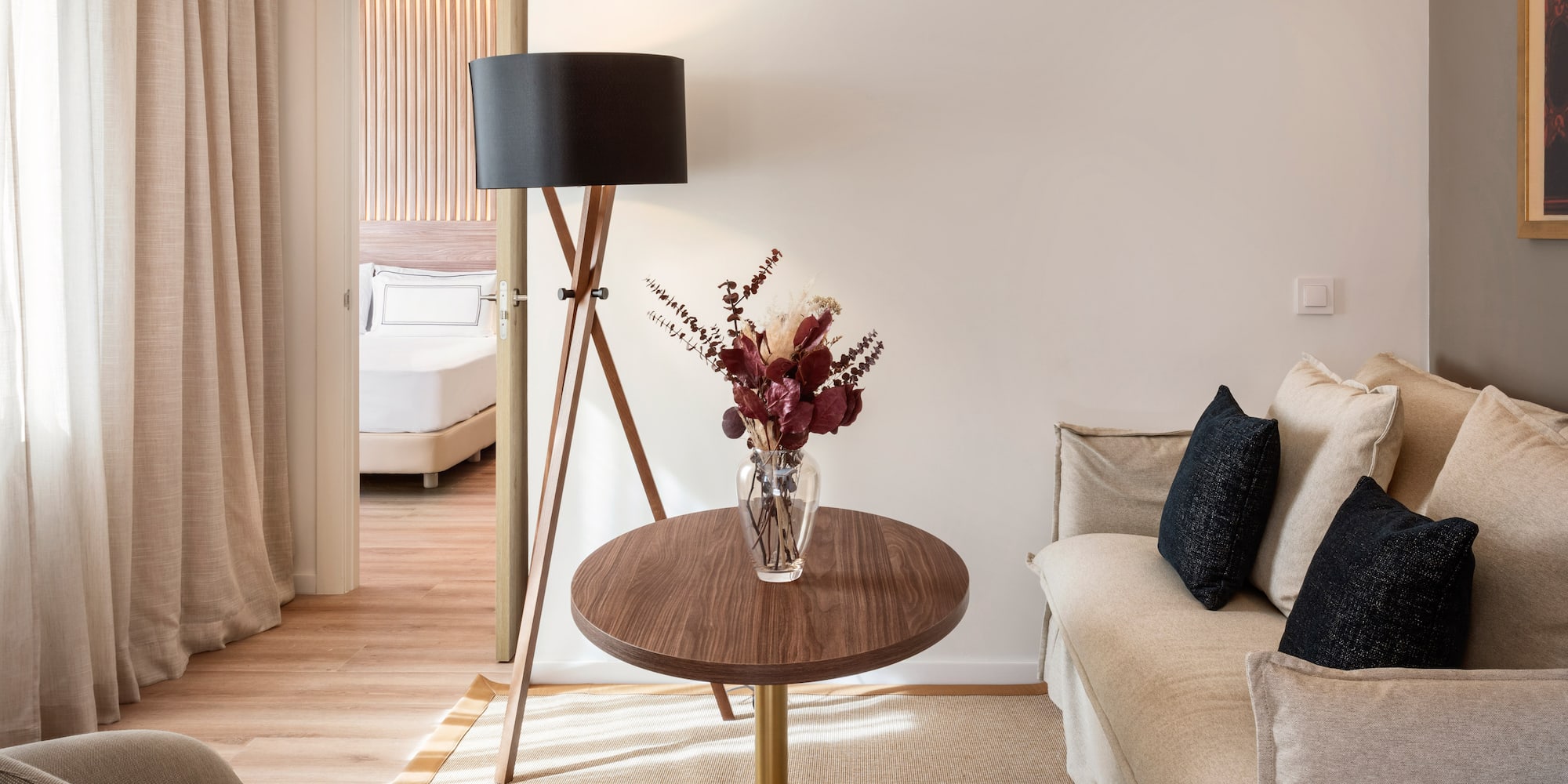 a living room with a couch and a vase of flowers