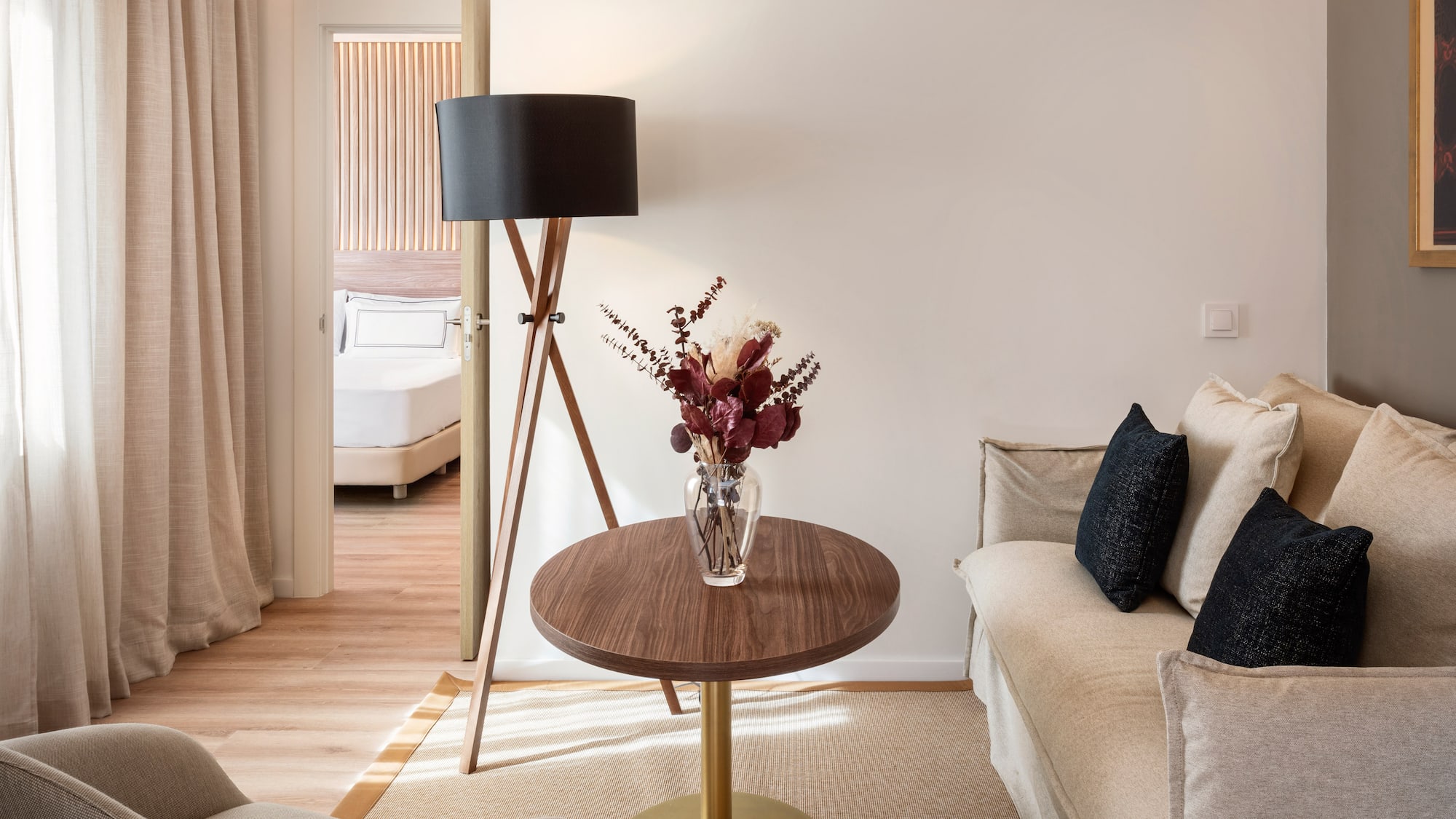 a living room with a couch and a vase of flowers