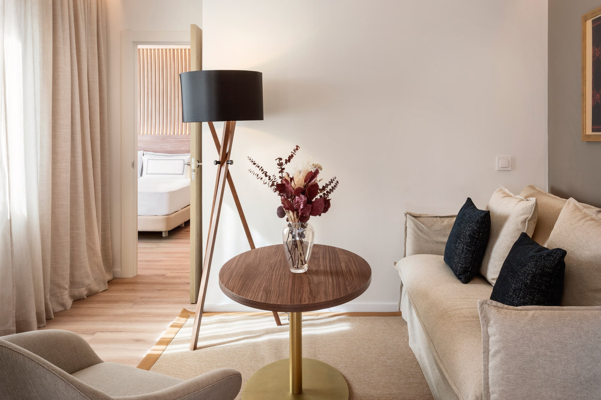 a living room with a couch and a vase of flowers