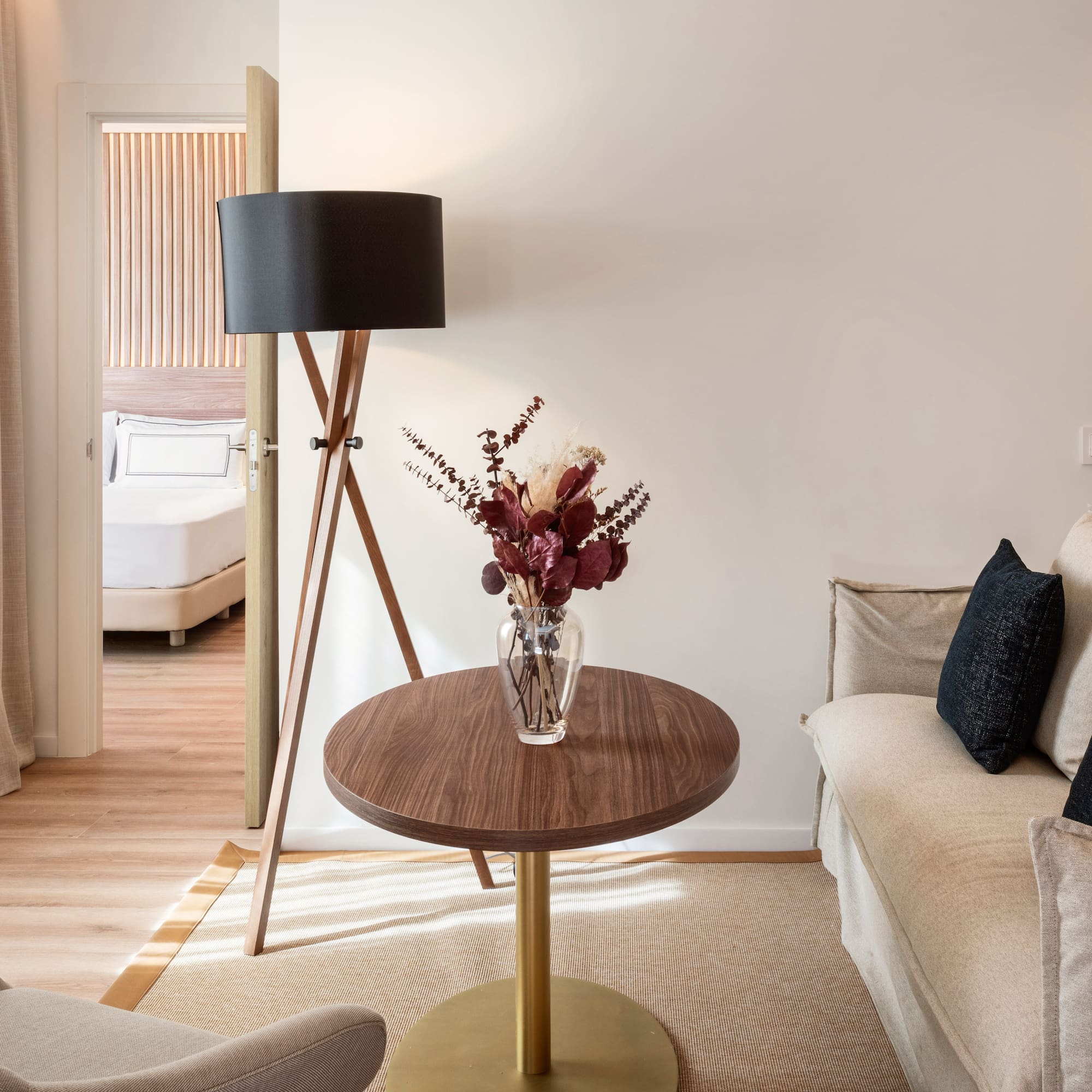 a living room with a couch and a vase of flowers