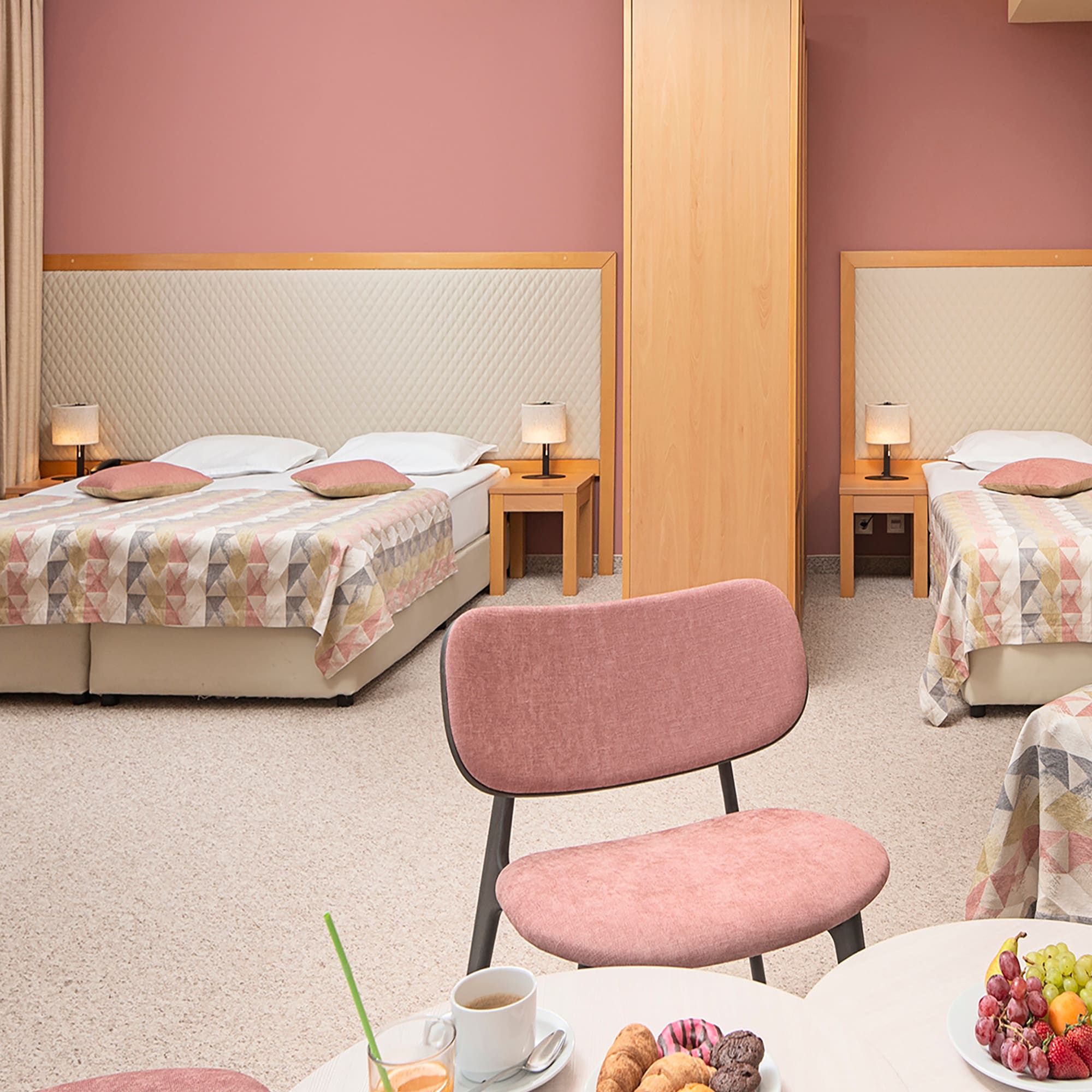 a room with two beds and a table with food