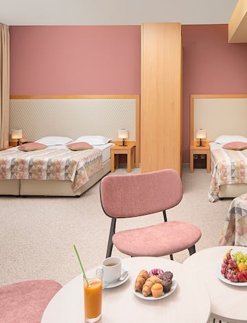 a room with two beds and a table with food