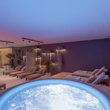 a room with a hot tub and lounge chairs
