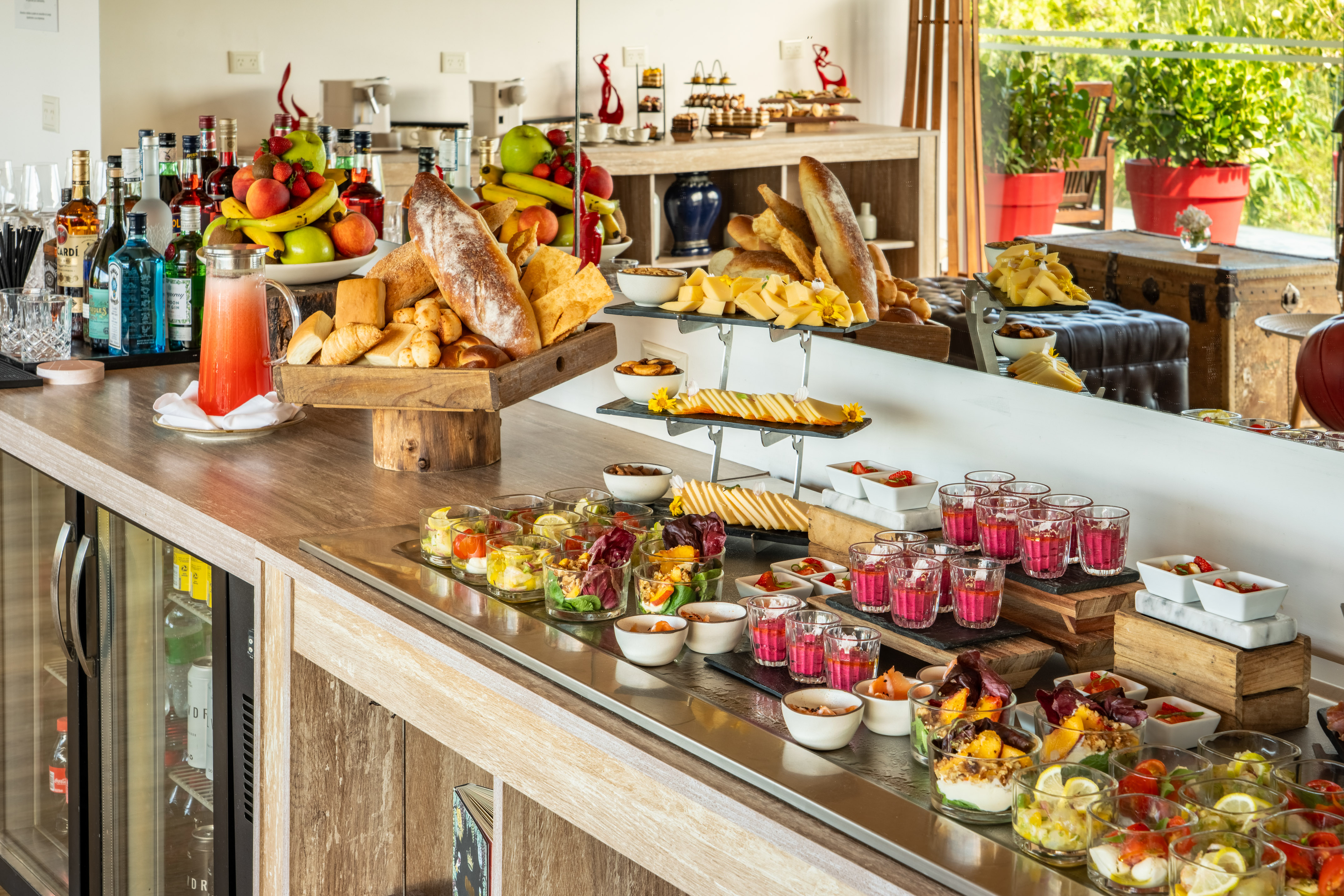 Gourmet buffet spread with fresh fruit, artisan bread, cheeses, salads, and drinks.
