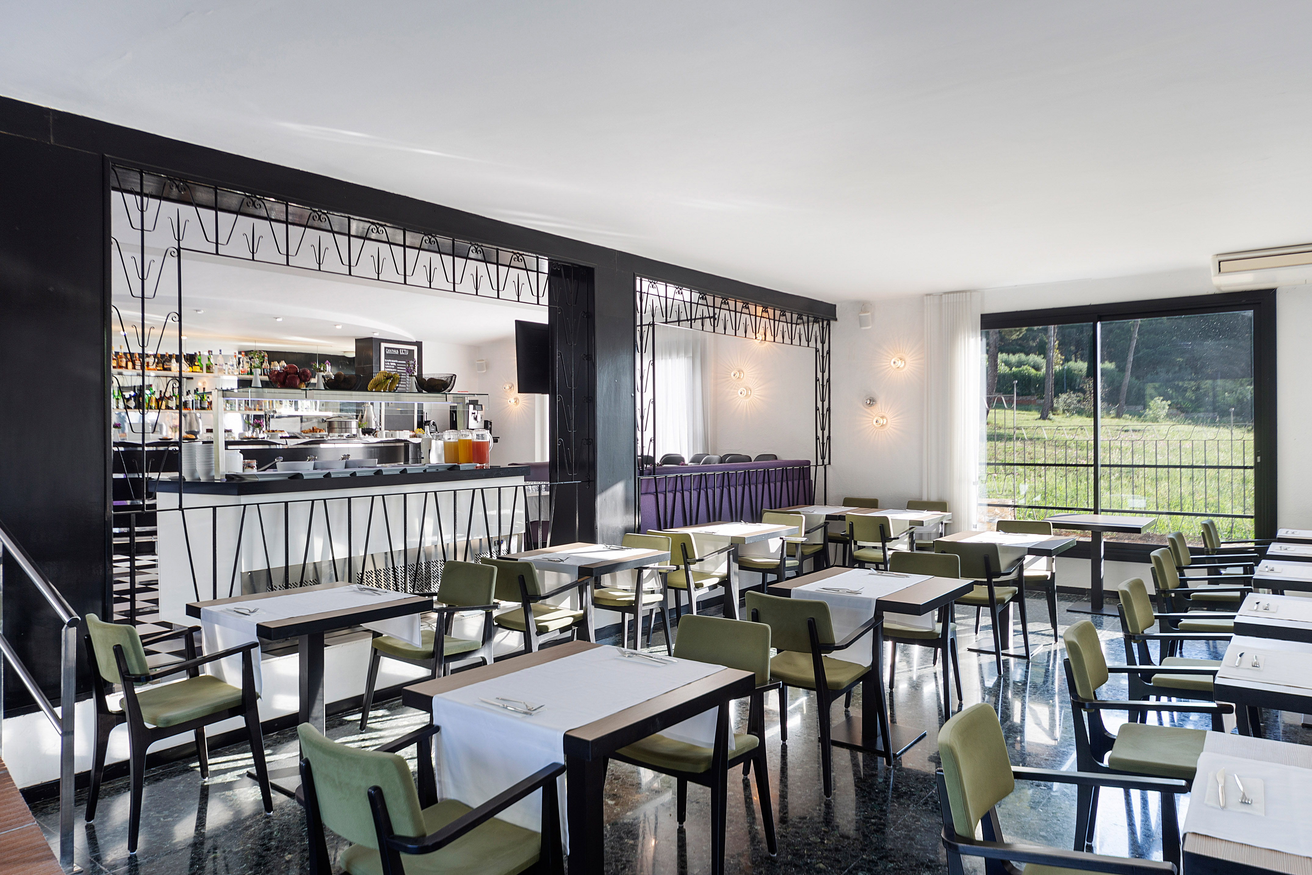 Modern restaurant dining room with buffet, tables, chairs, and outdoor view.