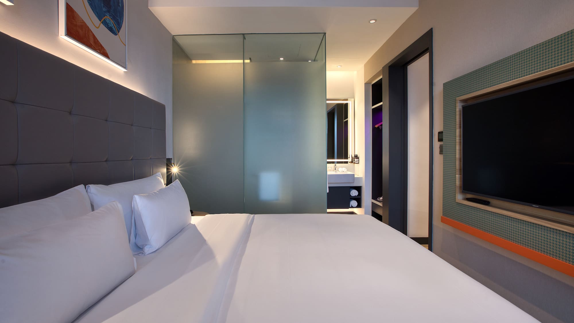 a bed with white sheets and a glass shower door