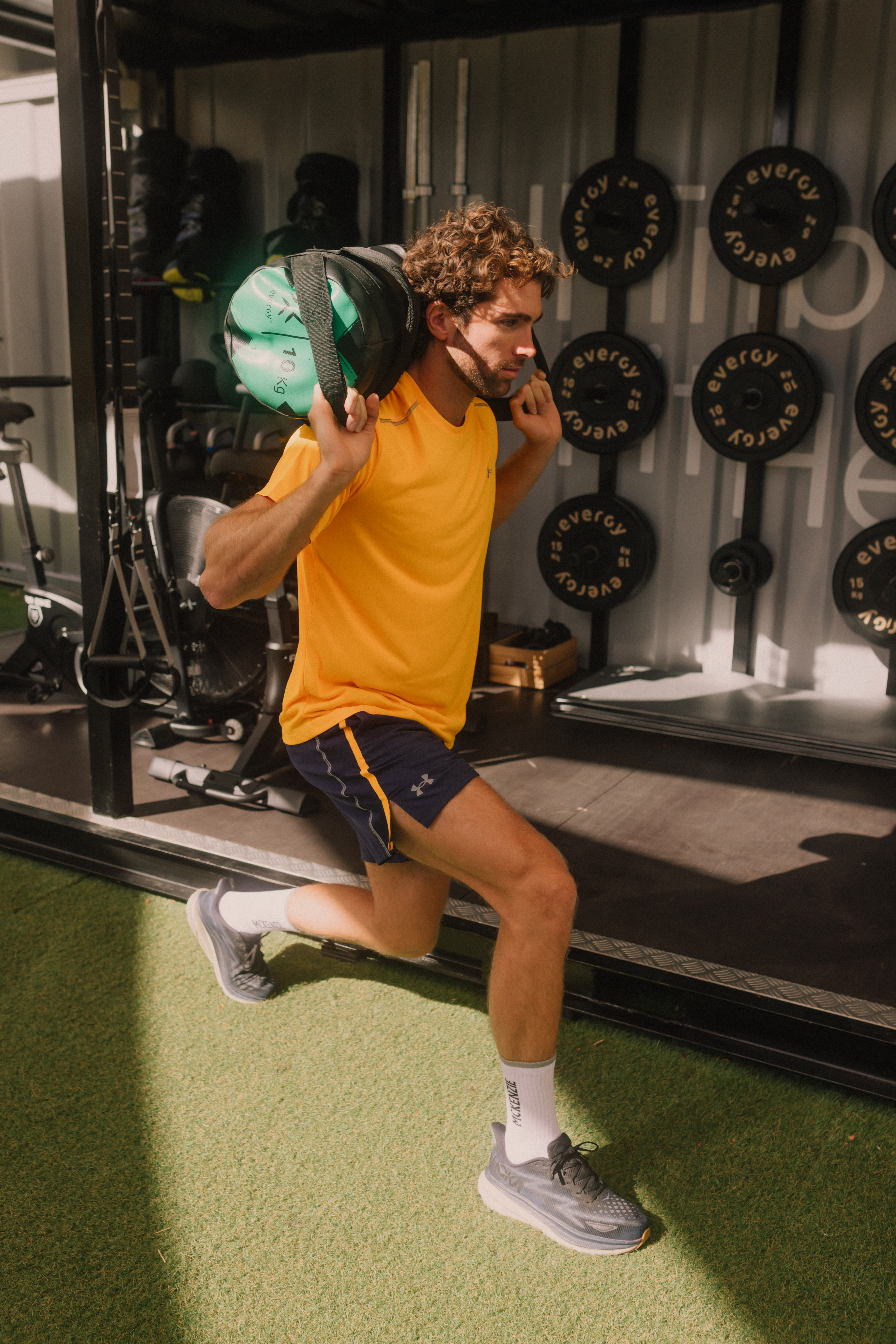 a man in a yellow shirt carrying a weight bag