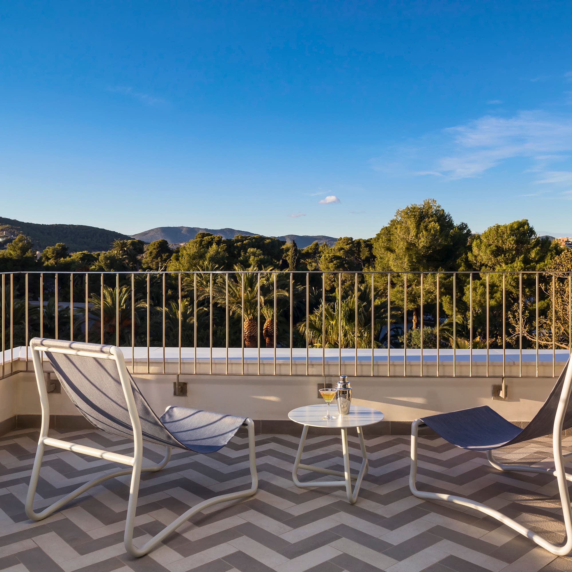 chairs on a balcony with trees in the background