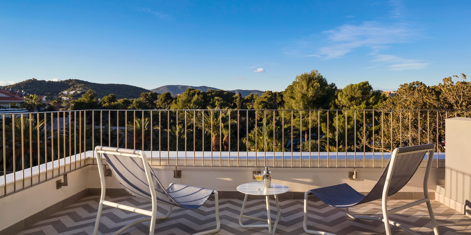chairs on a balcony with trees in the background