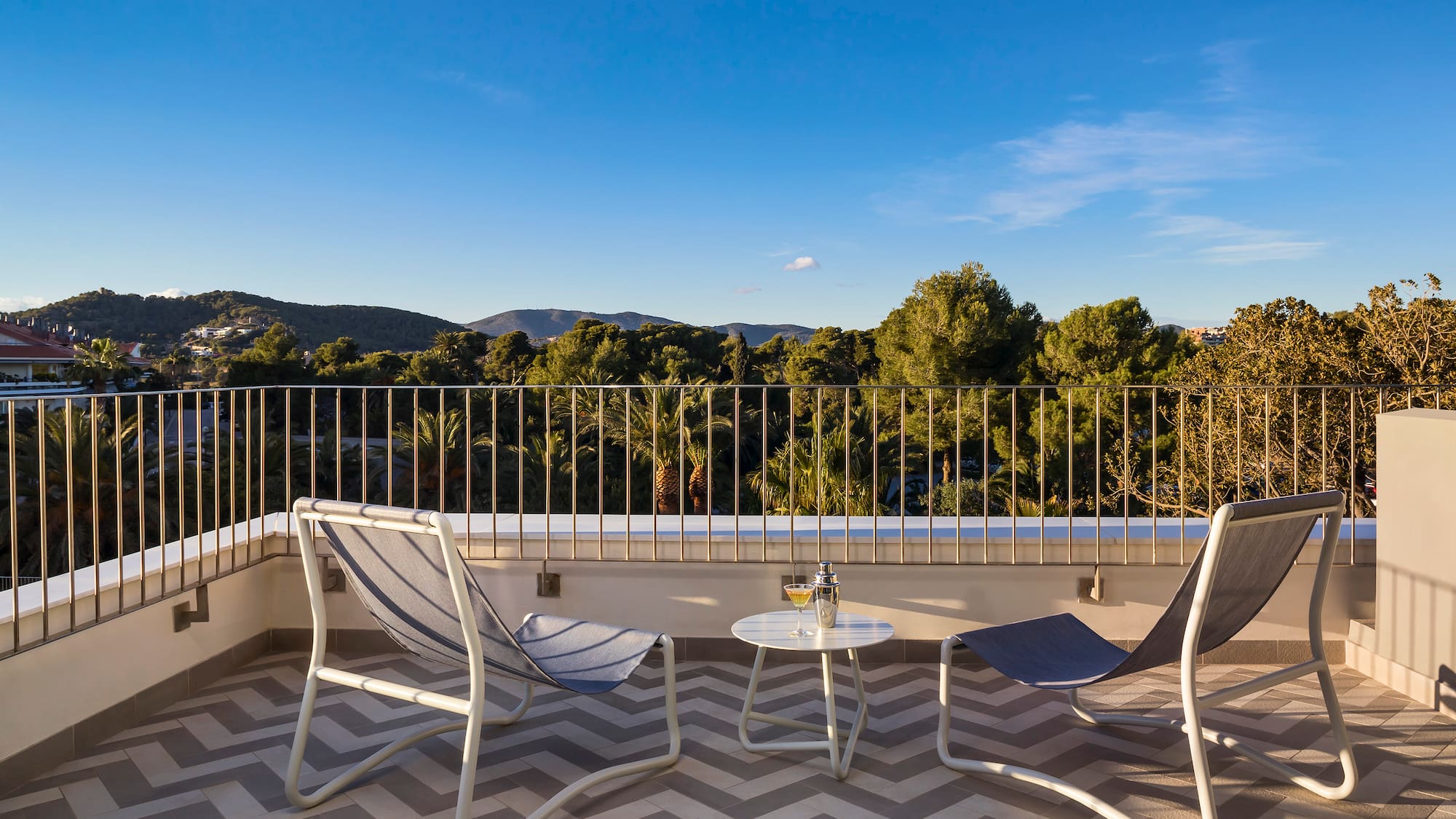 chairs on a balcony with trees in the background