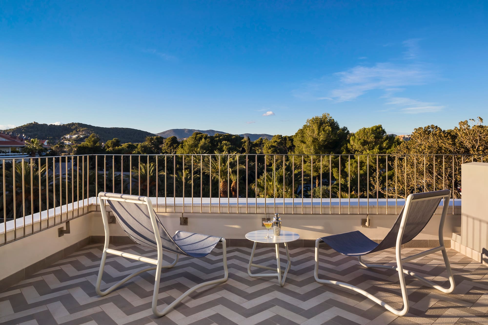 chairs on a balcony with trees in the background