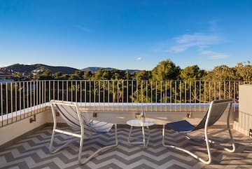 chairs on a balcony with trees in the background