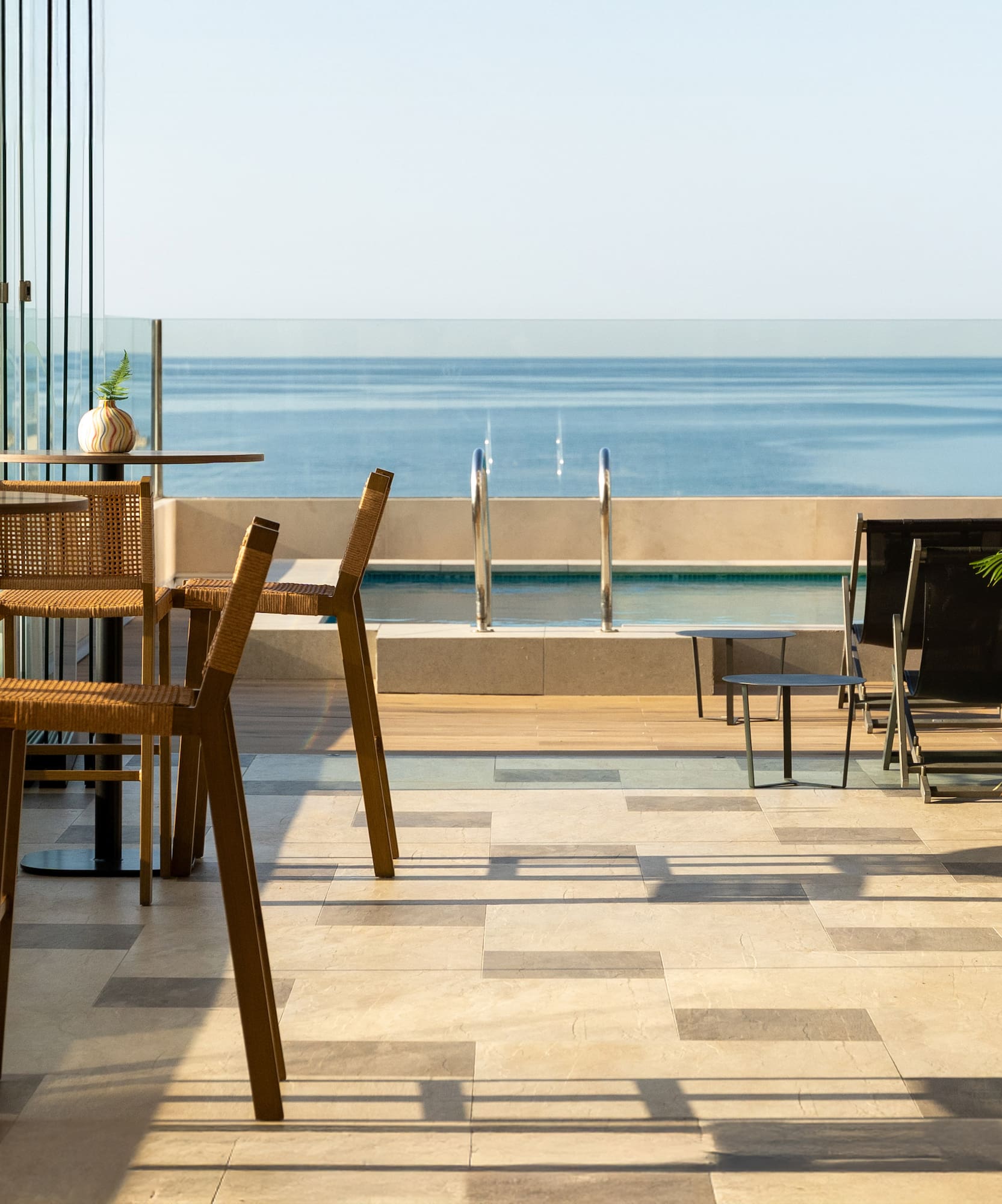 a patio with chairs and a view of the ocean