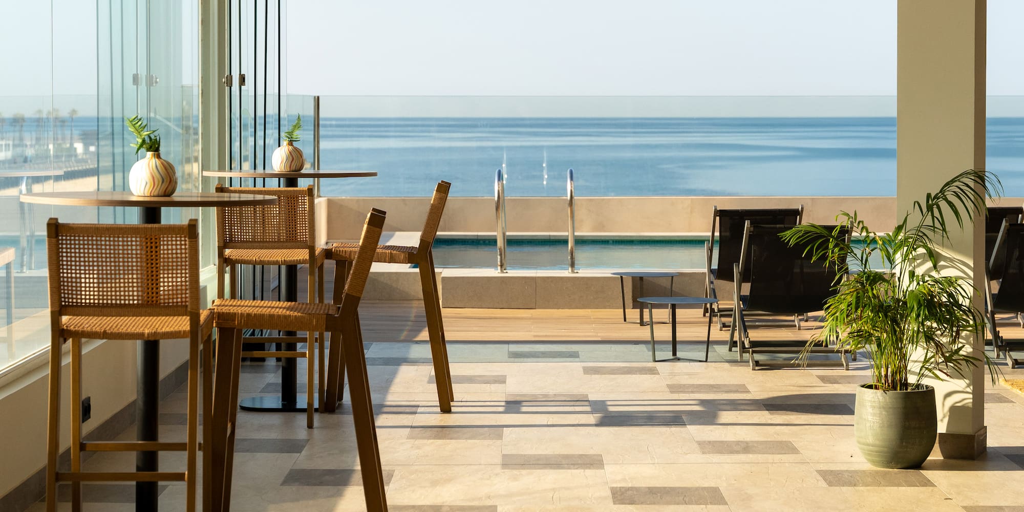 a patio with chairs and a view of the ocean