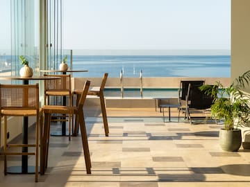 a patio with chairs and a view of the ocean