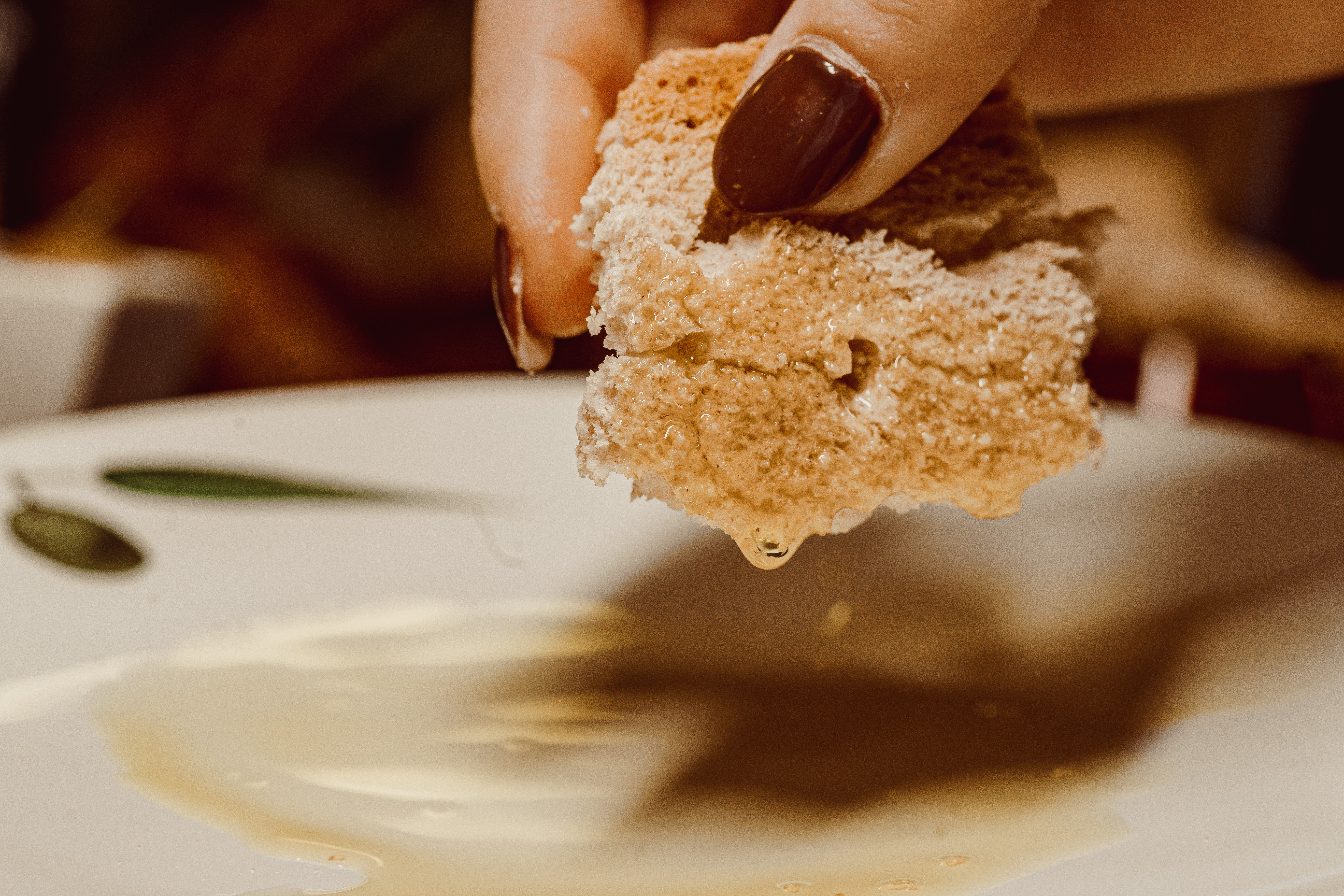 a hand holding a piece of bread