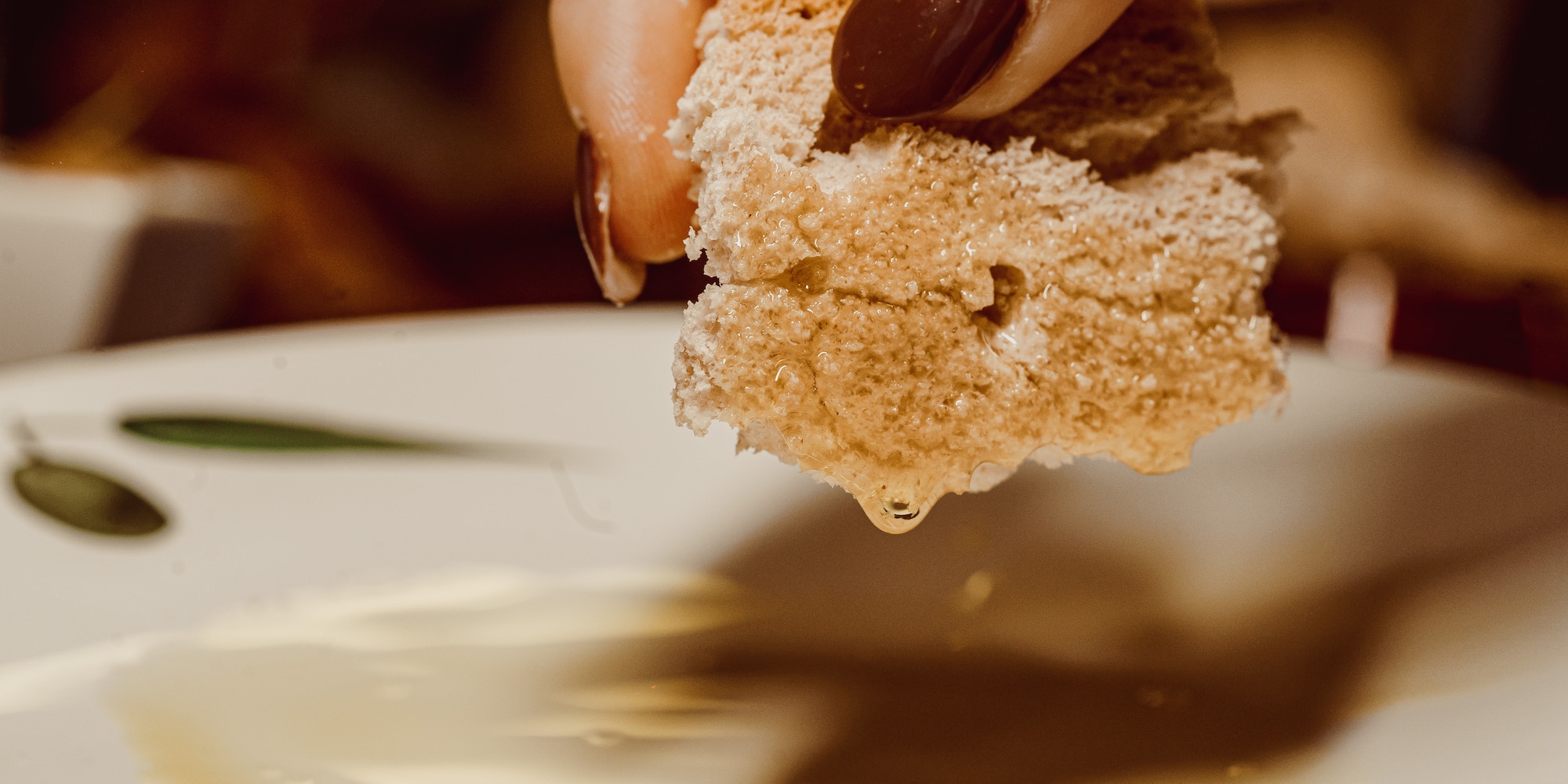 a hand holding a piece of bread