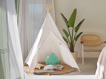 a teepee with a book and a plant in the background