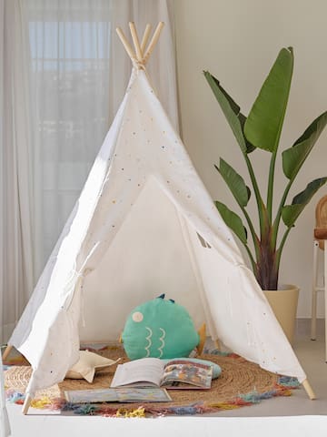 a teepee with a book and a plant in the background