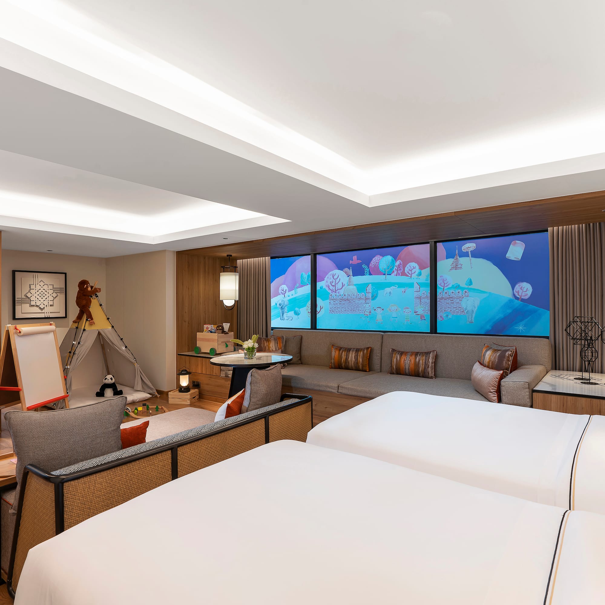 a room with two beds and a large screen