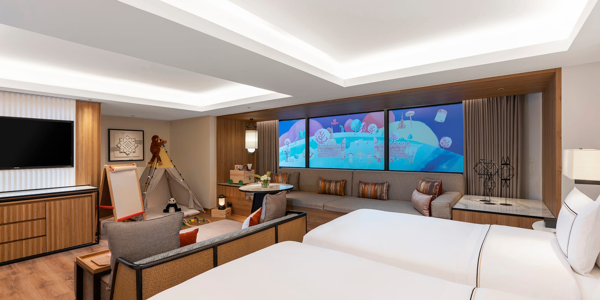 a room with two beds and a large screen