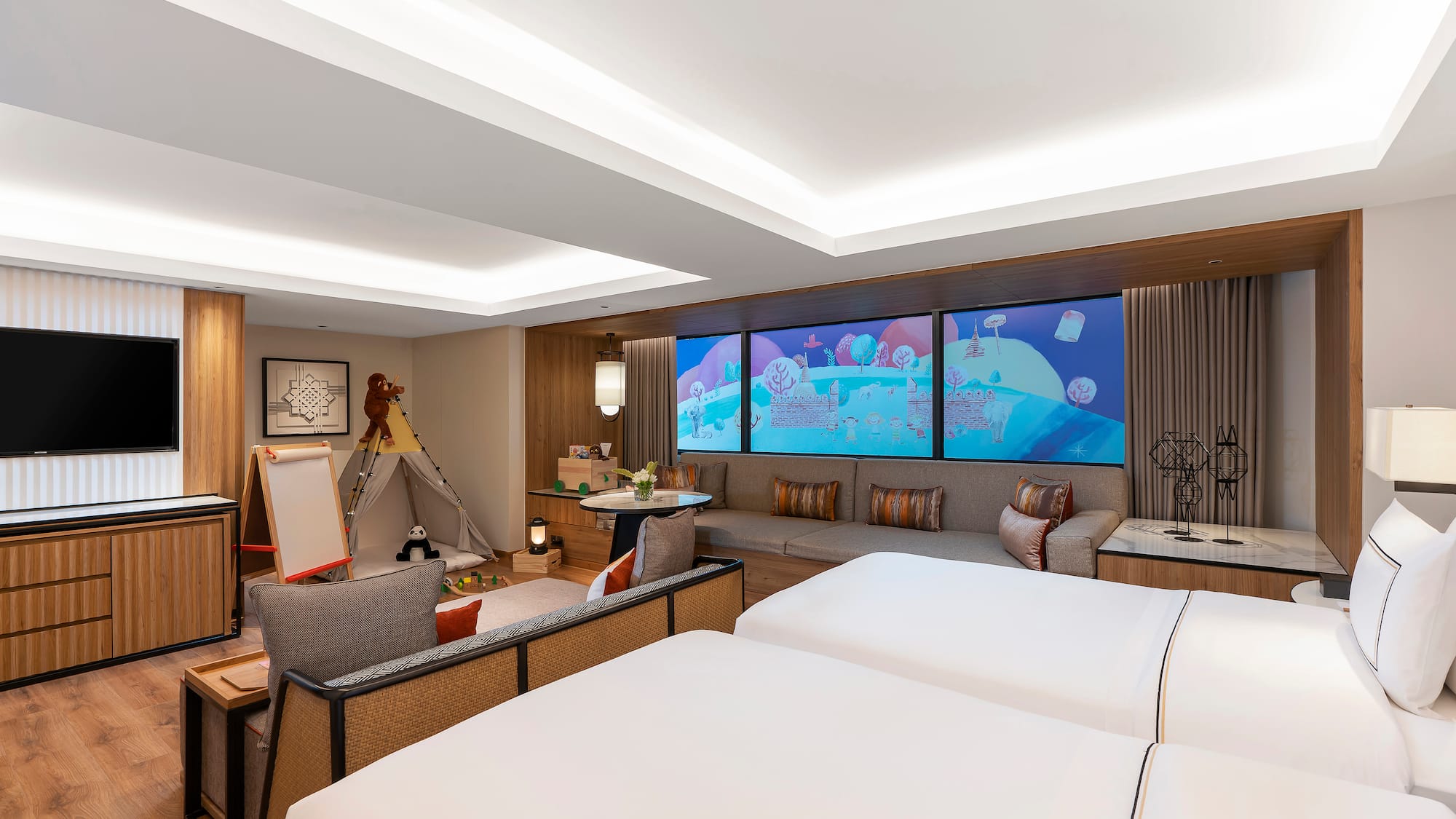 a room with two beds and a large screen