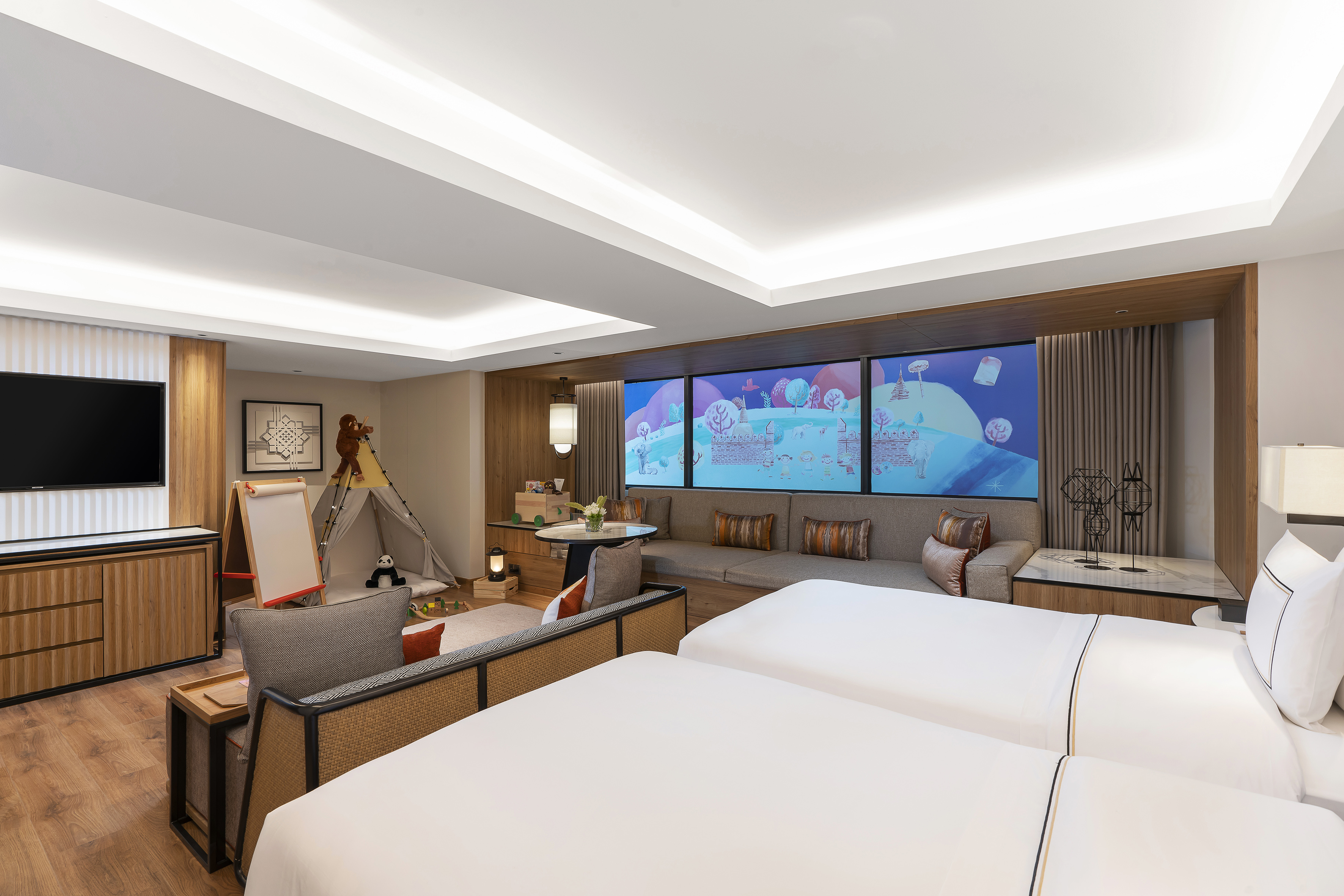 a room with two beds and a large screen