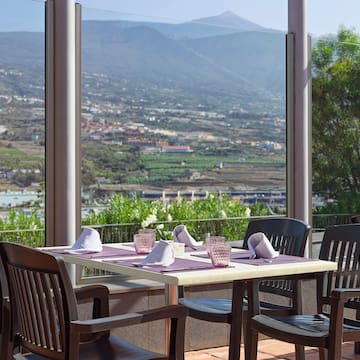 a table and chairs outside with a view of a valley and mountains