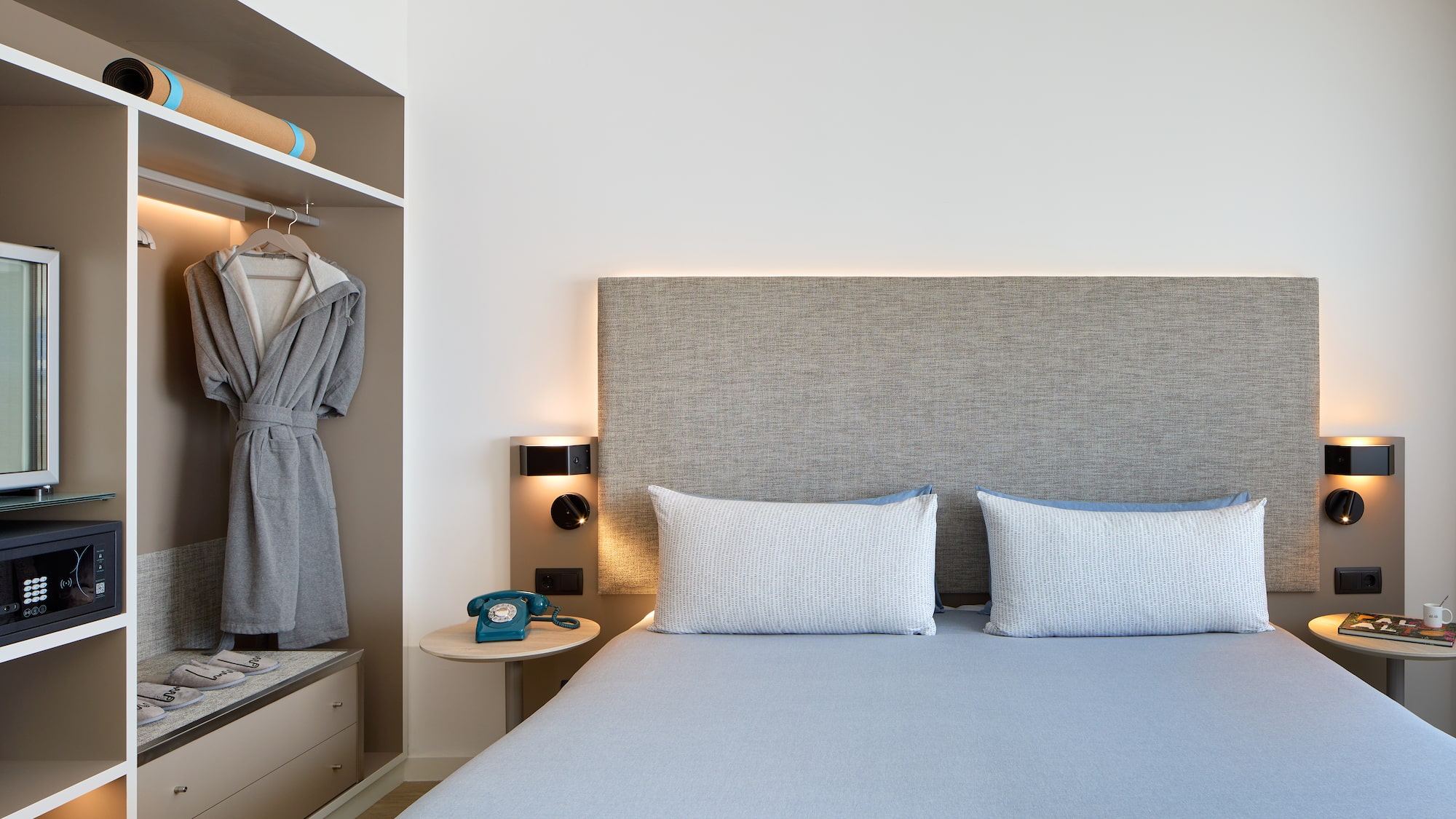 a bed with a headboard and a towel on the shelf