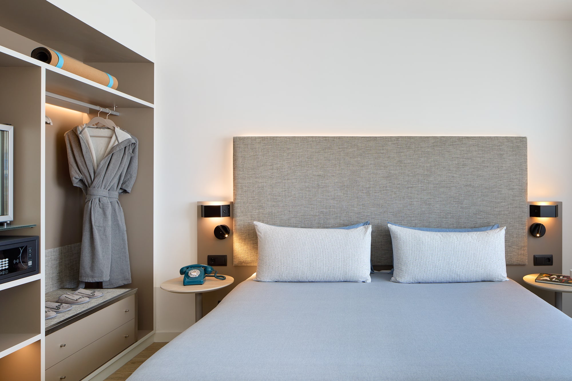 a bed with a headboard and a towel on the shelf