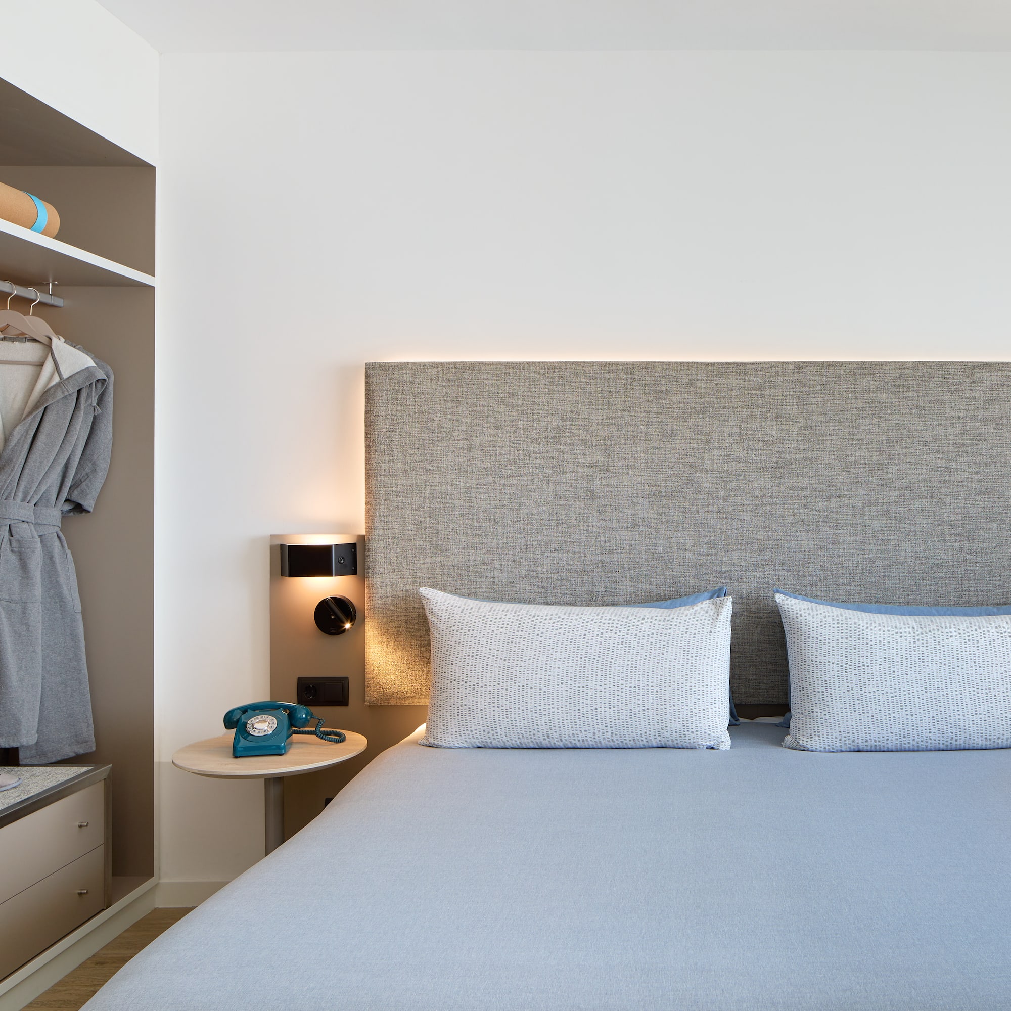 a bed with a headboard and a towel on the shelf