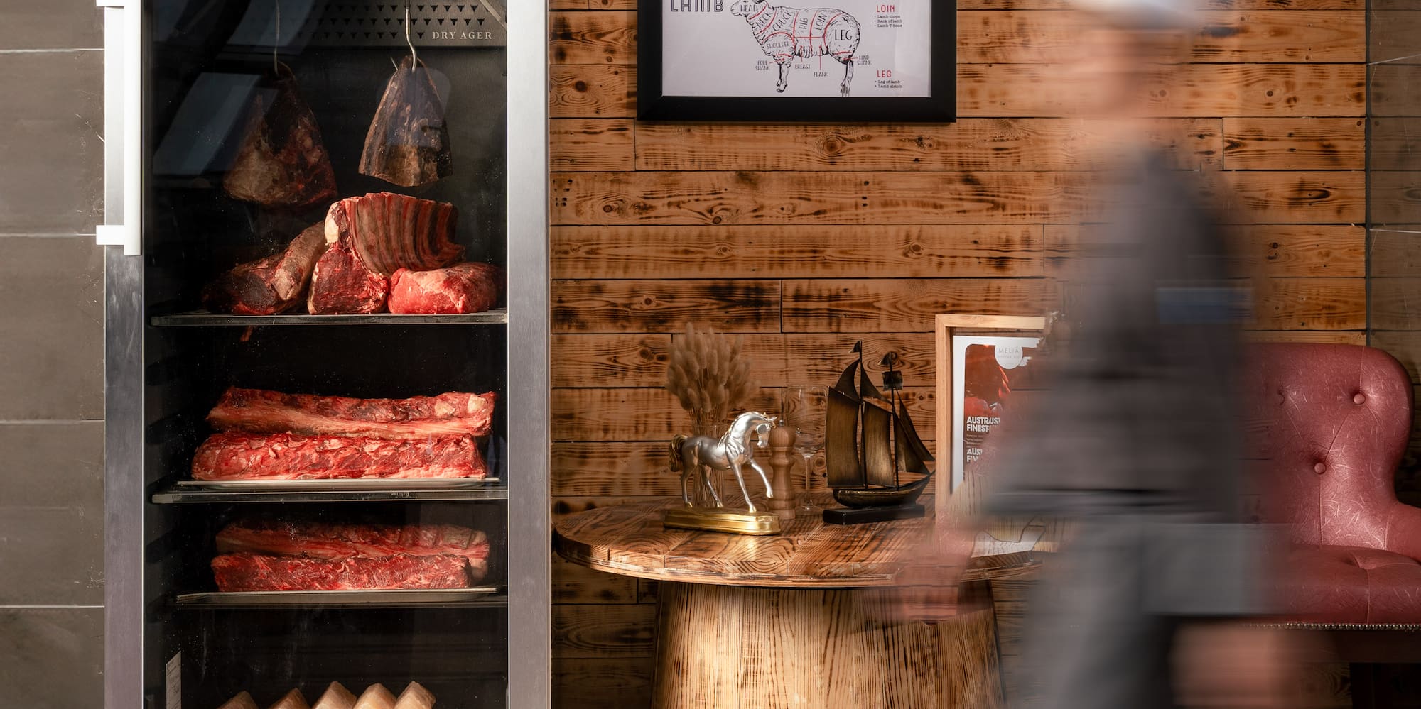 a chef walking past a display of meat