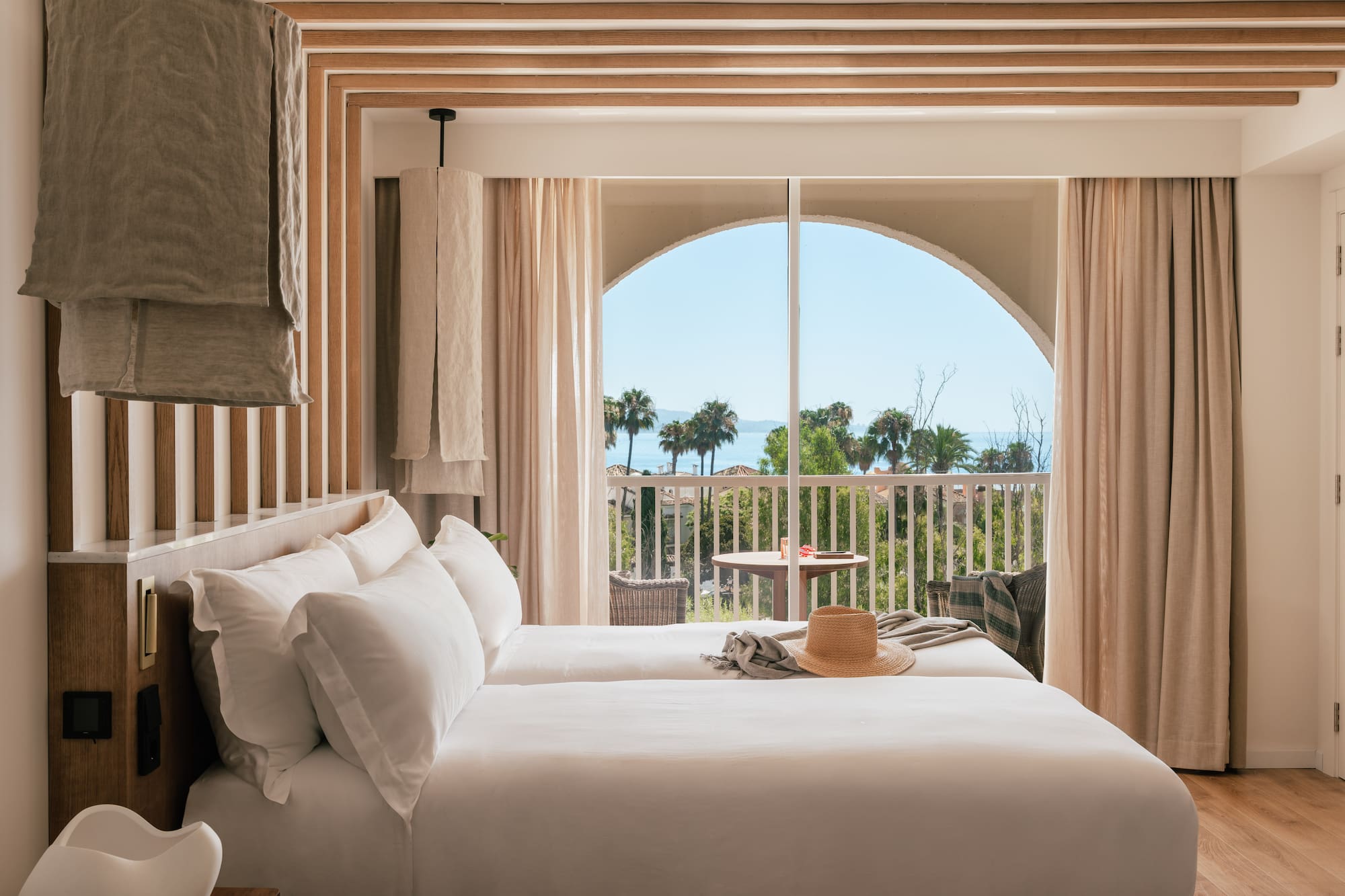 a room with a bed and a balcony overlooking the ocean