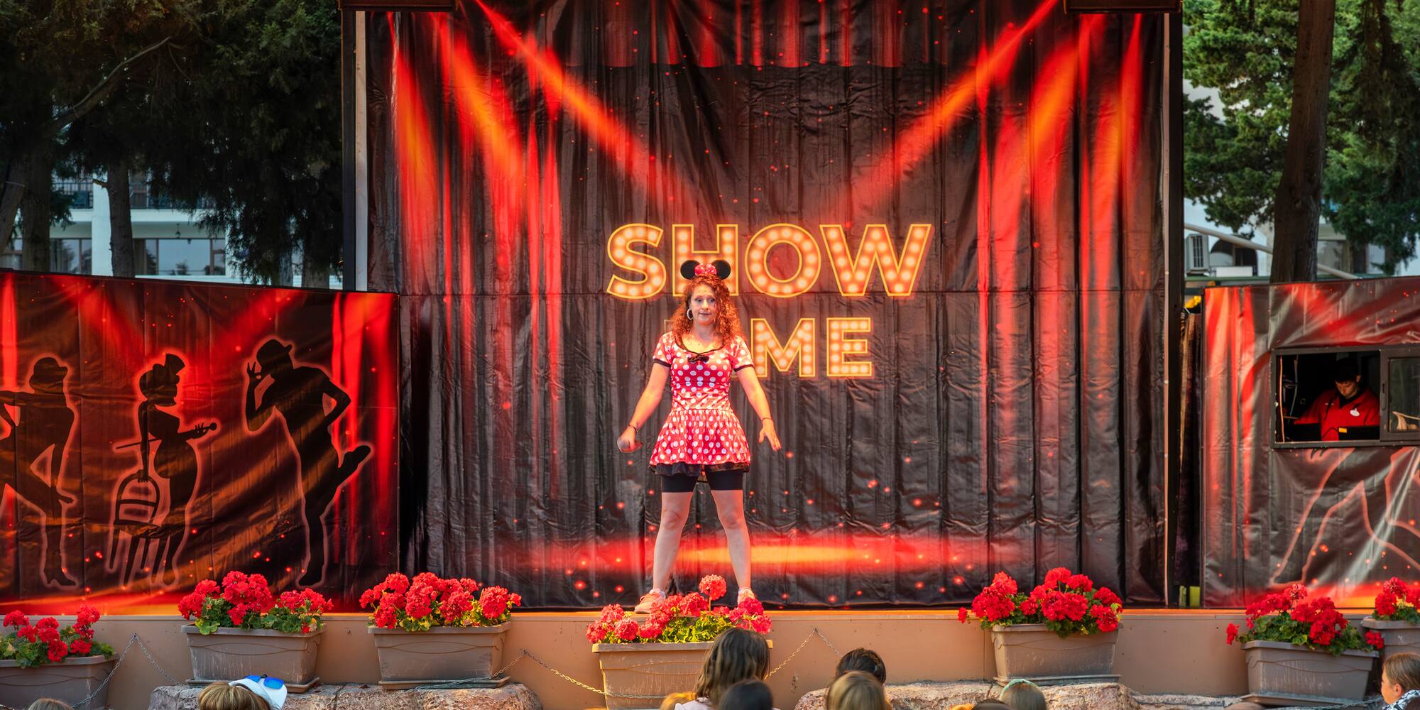 a woman on stage with a crowd of people watching