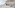 Bright, minimalist fashion boutique with clothing racks, plants, and large windows.