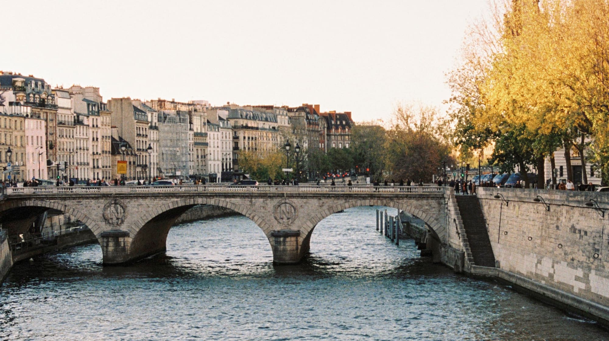a bridge over a river with buildings in the background