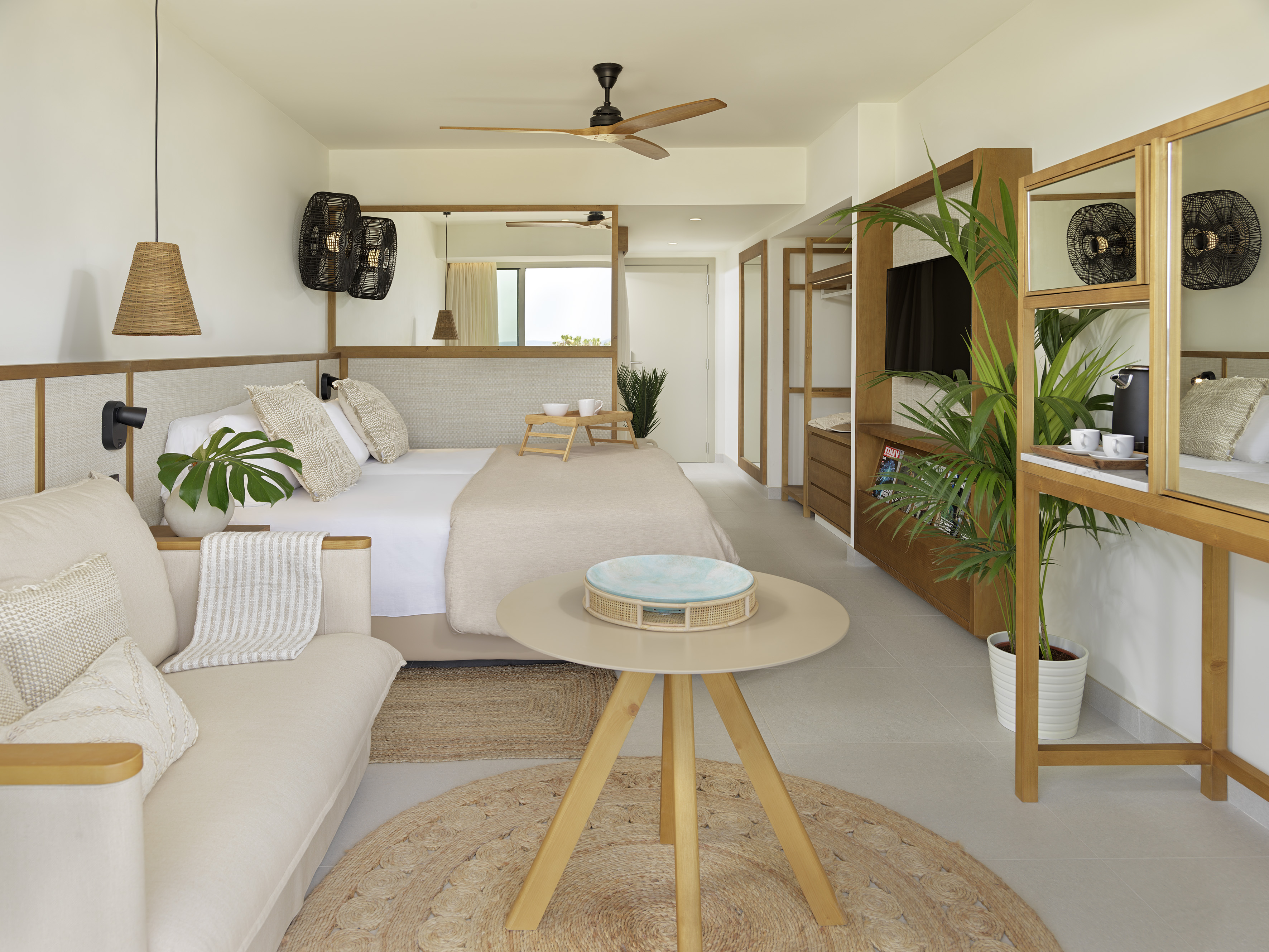Bright modern hotel room with neutral tones, wooden details, and natural textures.