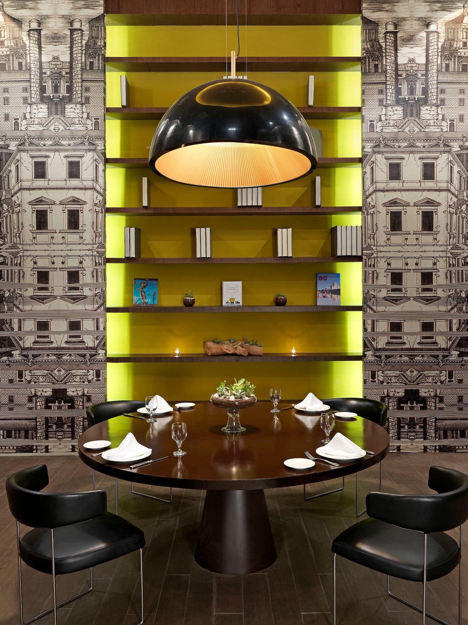 a table with chairs in a room with a wallpaper and a lamp