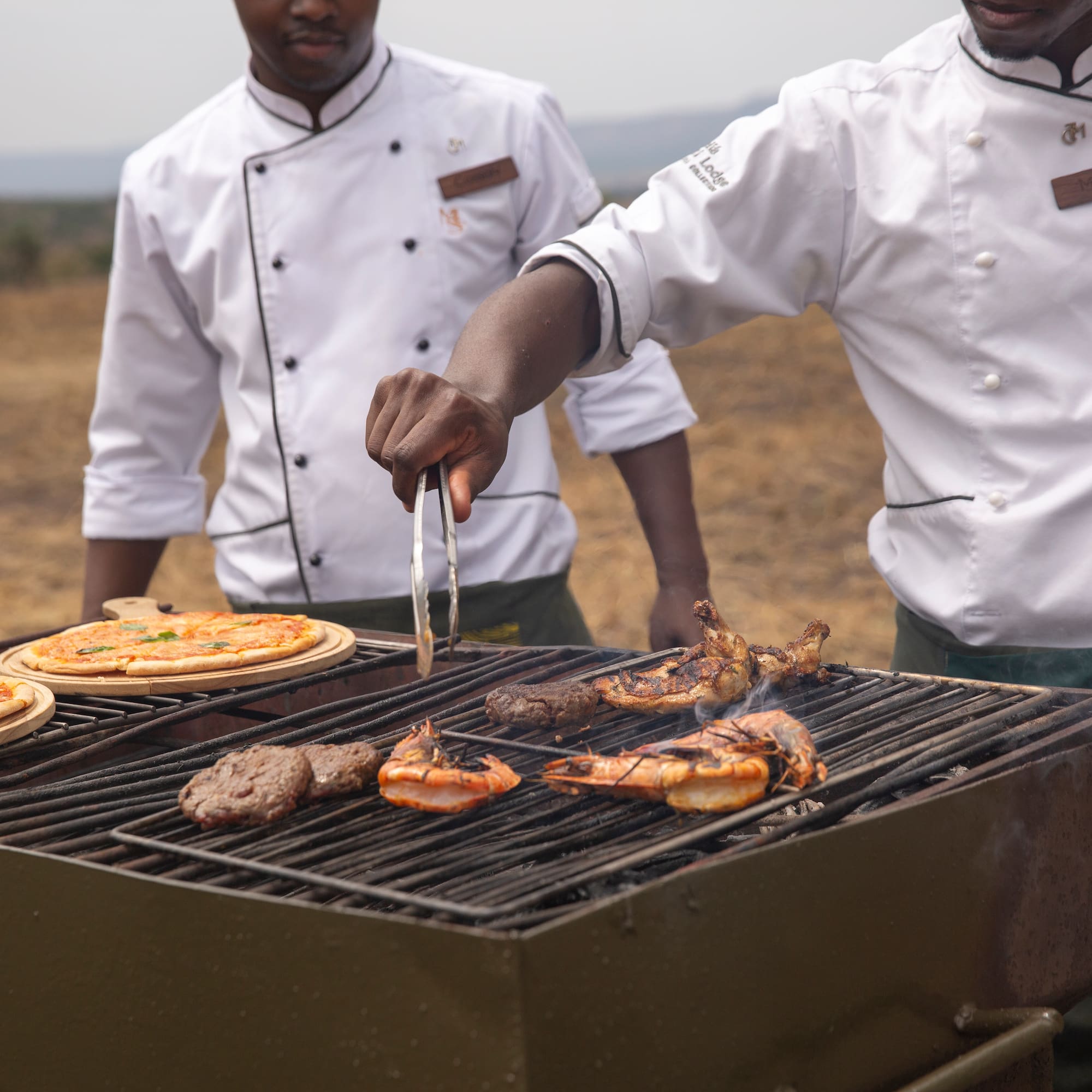 a group of men cooking food on a grill